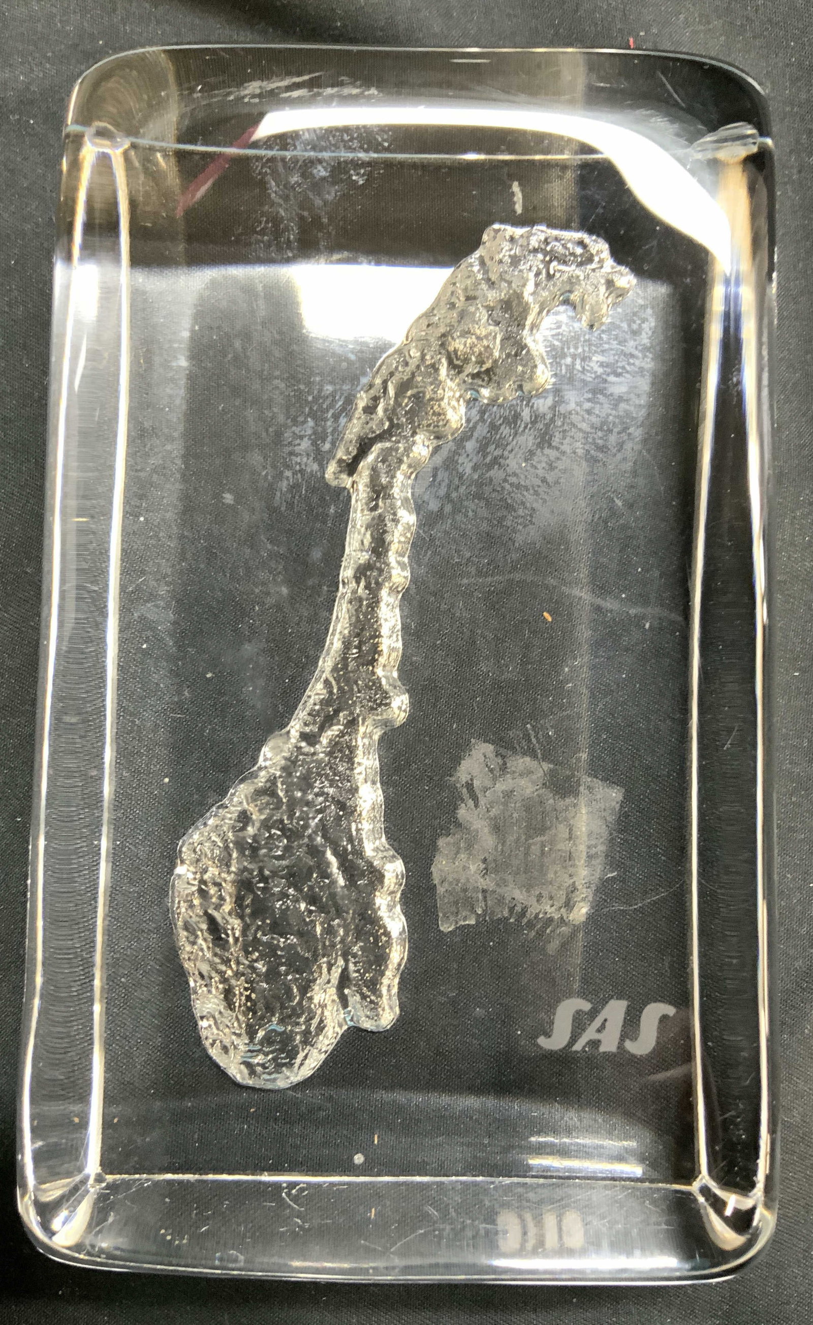 SAS SWEDEN Country Art Glass Paperweight: Paperweight reads SAS. Piece is glass. Paperweight has relief detail in the shape Sweden. Paperweight measures approximately 5 inches long 3 inches wide. Paperweight, art glass, art glass paperweight,