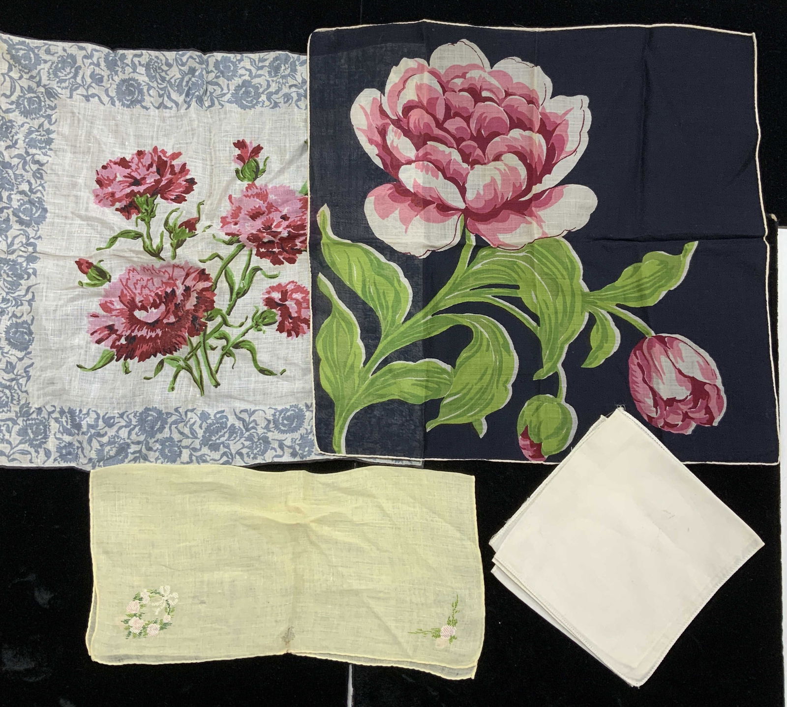 Collectible Linen & Cotton Hankies , 5: Linen hankie with bold flowers on a navy background and hand rolled trim. Measures 13 x 13.25 in. White and blue linen hankie with pink and green flowers. Yellow hand embroidered hankie , has a hole.