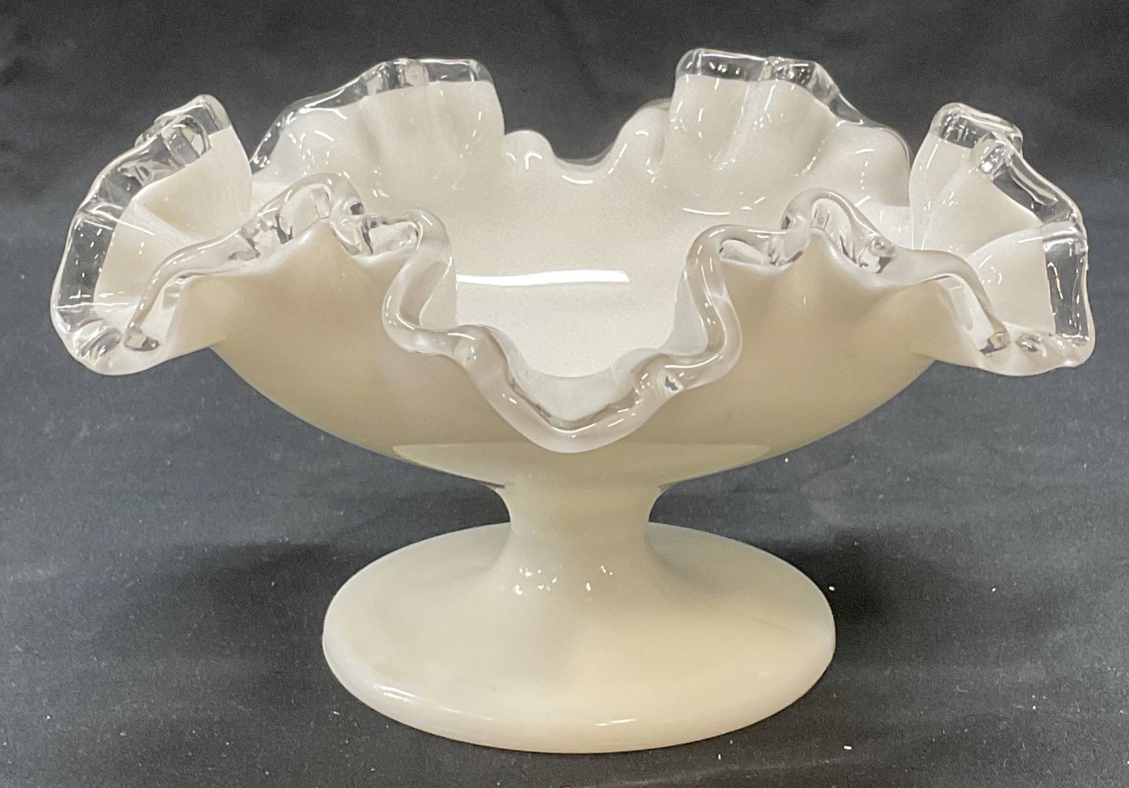 Milk Glass Footed Handkerchief Rim Bowl: Milk glass handkerchief rim bowl with footed base, thick walled glass, piece has weight. Measures approx. 7 x 4 inches. Some surface wear including scratching observed. Milk glass, art glass, art glas