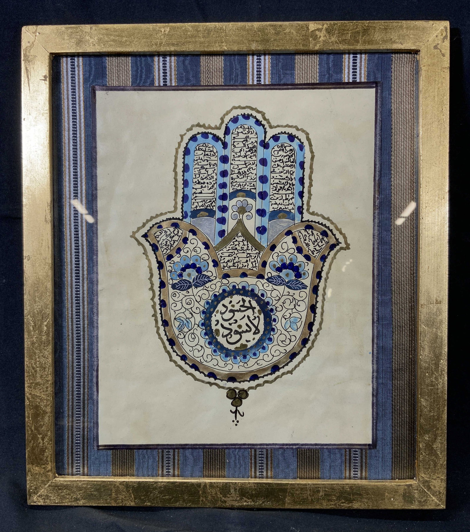 19th C. Sanskrit Illustrated Hamsa Hand: Hand painted and gold leafed illustration. 19th Century. Subject depicts a Hamsa hand with Sanskrit writing on the palm and fingers. Matte is an embroidered fabric with a blue and gold striped pattern