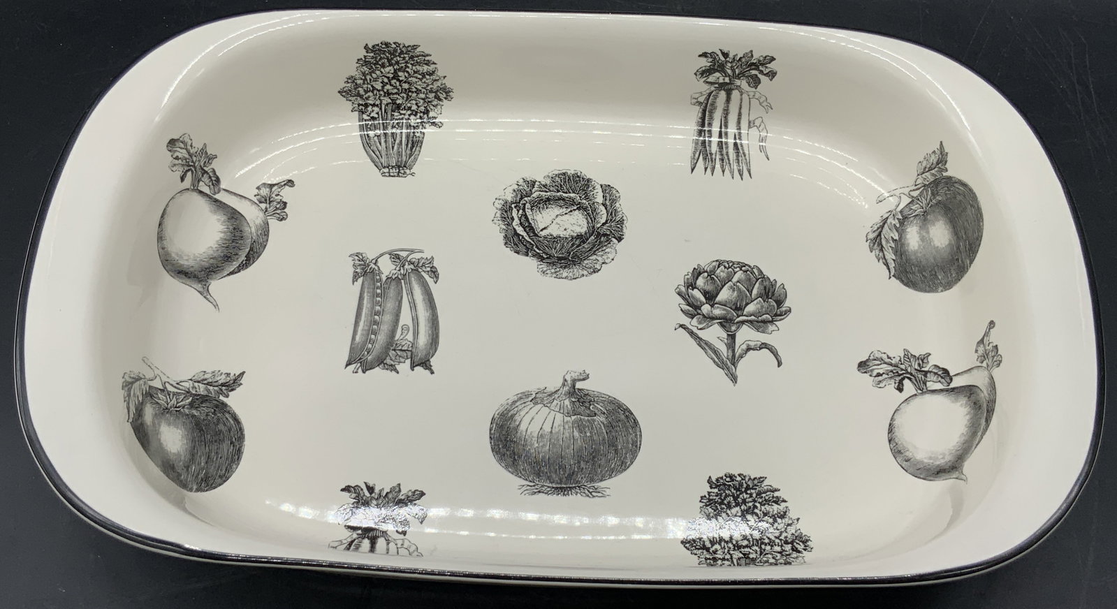 PFALTZGRAFF Farmers Market Pat Farrell Bakeware: A ceramic bakeware / casserole dish. Decorated with a vegetable motifs. Black, gray, and white hues. Underside signed PFALTZGRAFF Farmers Market by Pat Farrell. Measures approx. 2.25H x 13.75W in. Sur