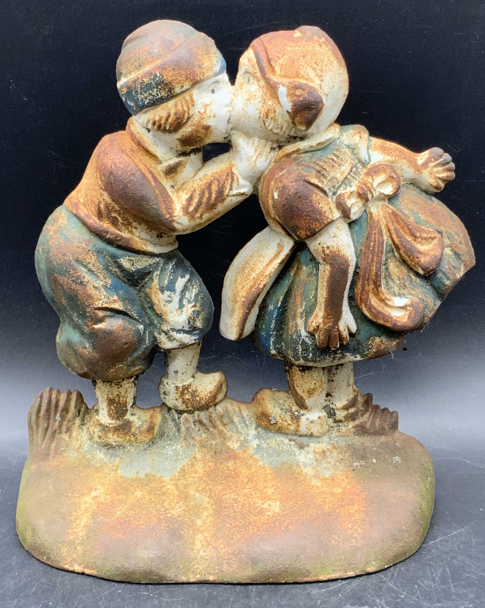 Vintage Cast Iron Kissing Figurals Doorstop: A vintage cast iron doorstop depicting two kissing figurals. Weighty piece. Measures approx, 8.5H x 7.5W in. Losses to paint. Wear consistent with age, use, and exposure. Collectibles, doorstopper, me