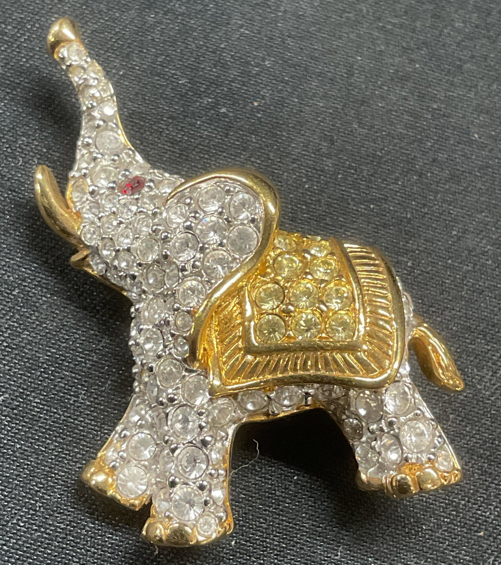 Swarovski Gold Plated Crystal Elephant Brooch: Swarovski gold plated elephant motif brooch. Colorless and red crystal decoration. Hinge pin to underside. Signed to underside. Measures approx. 1.25 x 1.5 inches. Some surface wear including scratchi