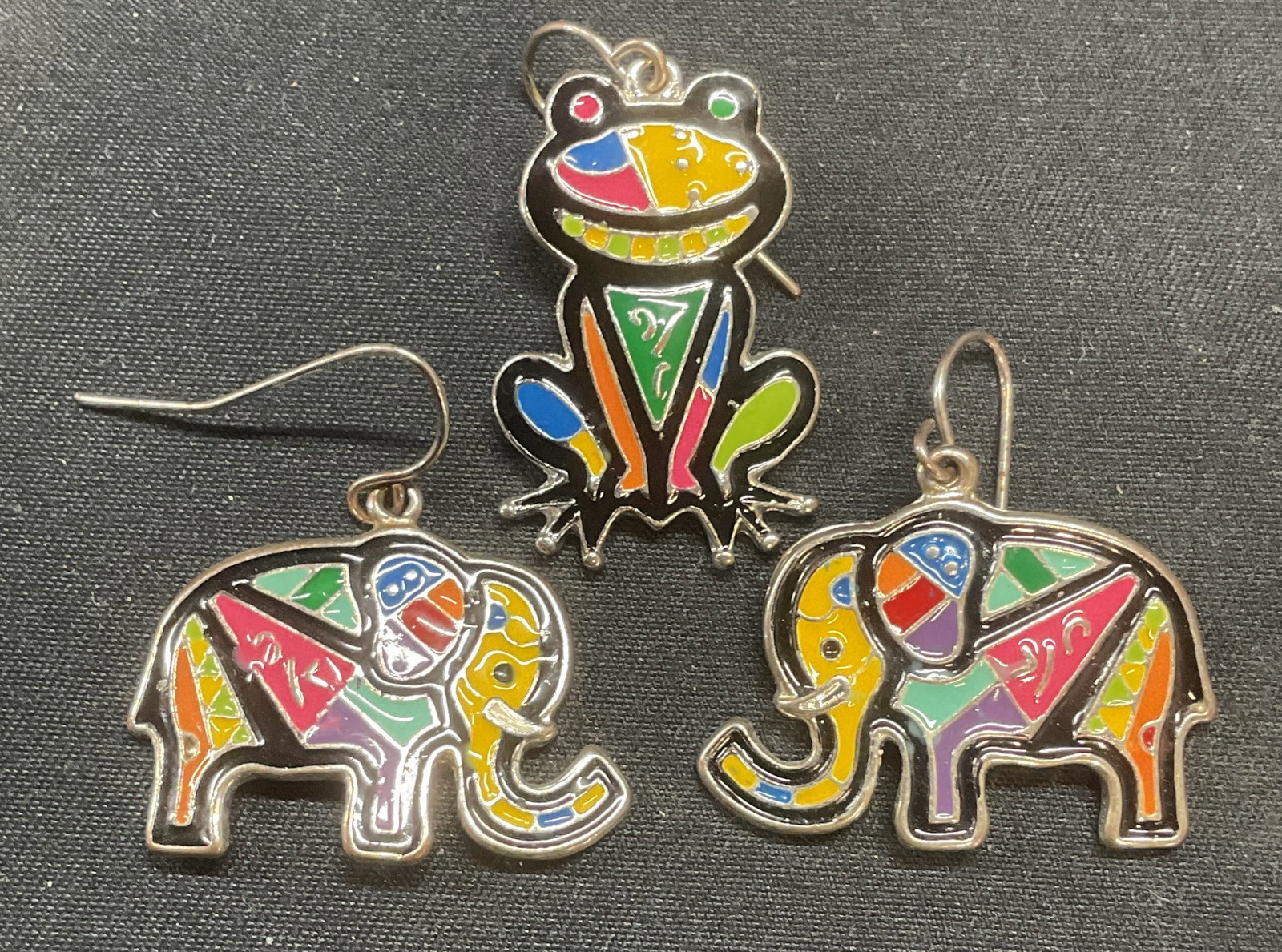 Lot 2 Silver Tn Enamel Elephant & Frog Earrings: Silver tone and multi color enameled elephant and frog motif earrings. Frog is single earring only. Hook backing. Largest piece measures approx. 1 x .75 inches. All pieces have some surface wear inclu