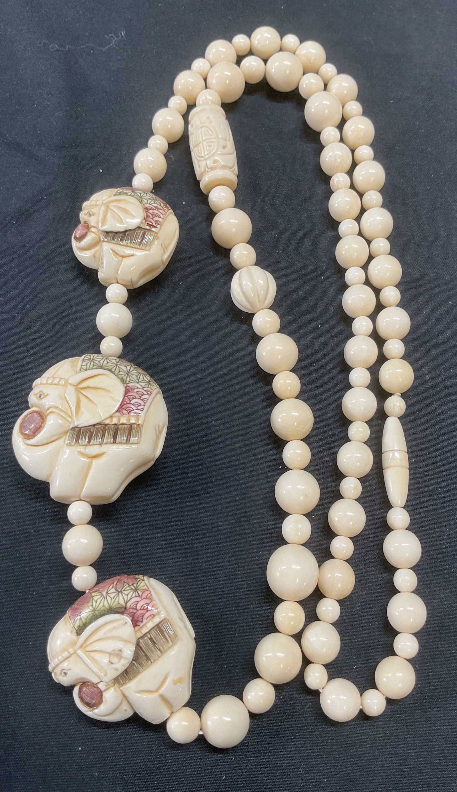 Asian Carved Bone Elephant Pendant Necklace: Asian carved bone round beaded necklace with carved elephant motif pendants. Hand painted. Drop length approx. 16 inches. Some surface wear including scratching observed. Jewelry, estate jewelry, cost