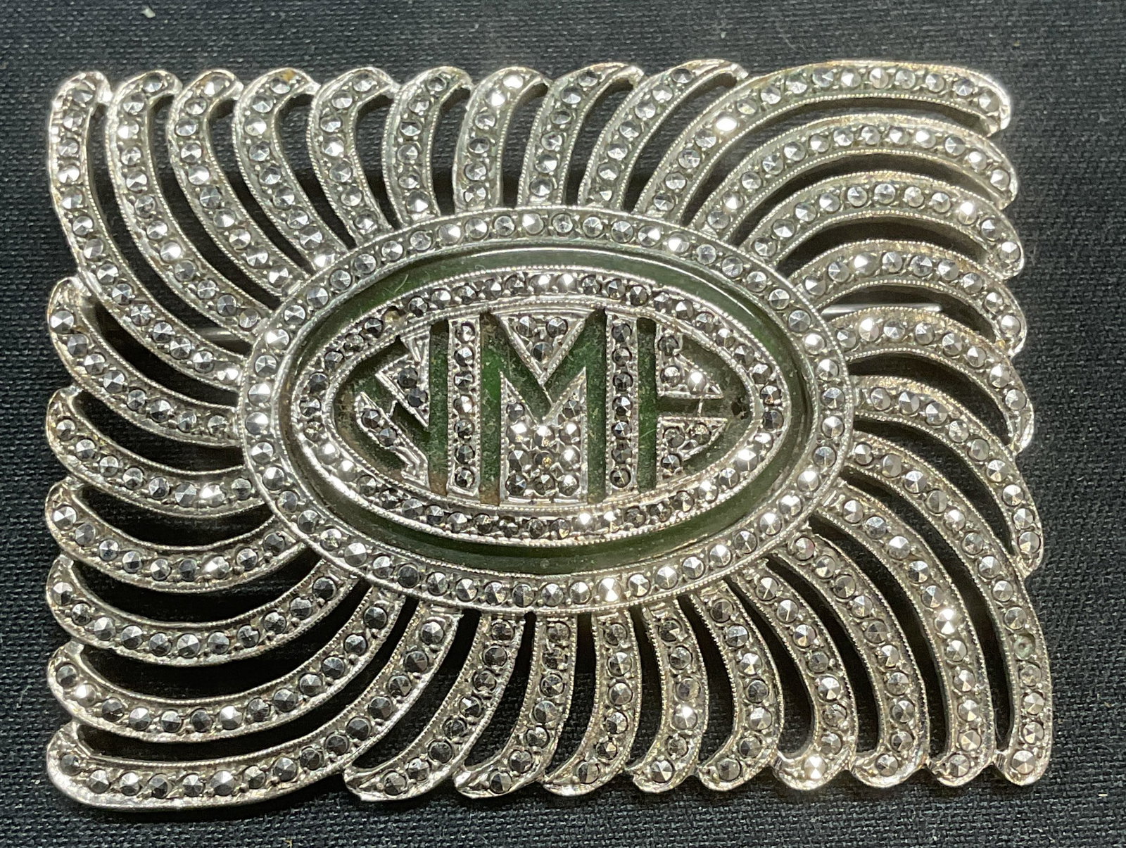 Sterling Silver & Marcasite Monogram Brooch: Sterling silver brooch with Marcasite decoration and monogram motif. HMH. Marked sterling. Measures approx. 1.5 x 2 inches. Total weight 21.1 grams. Some surface wear including scratching observed. So