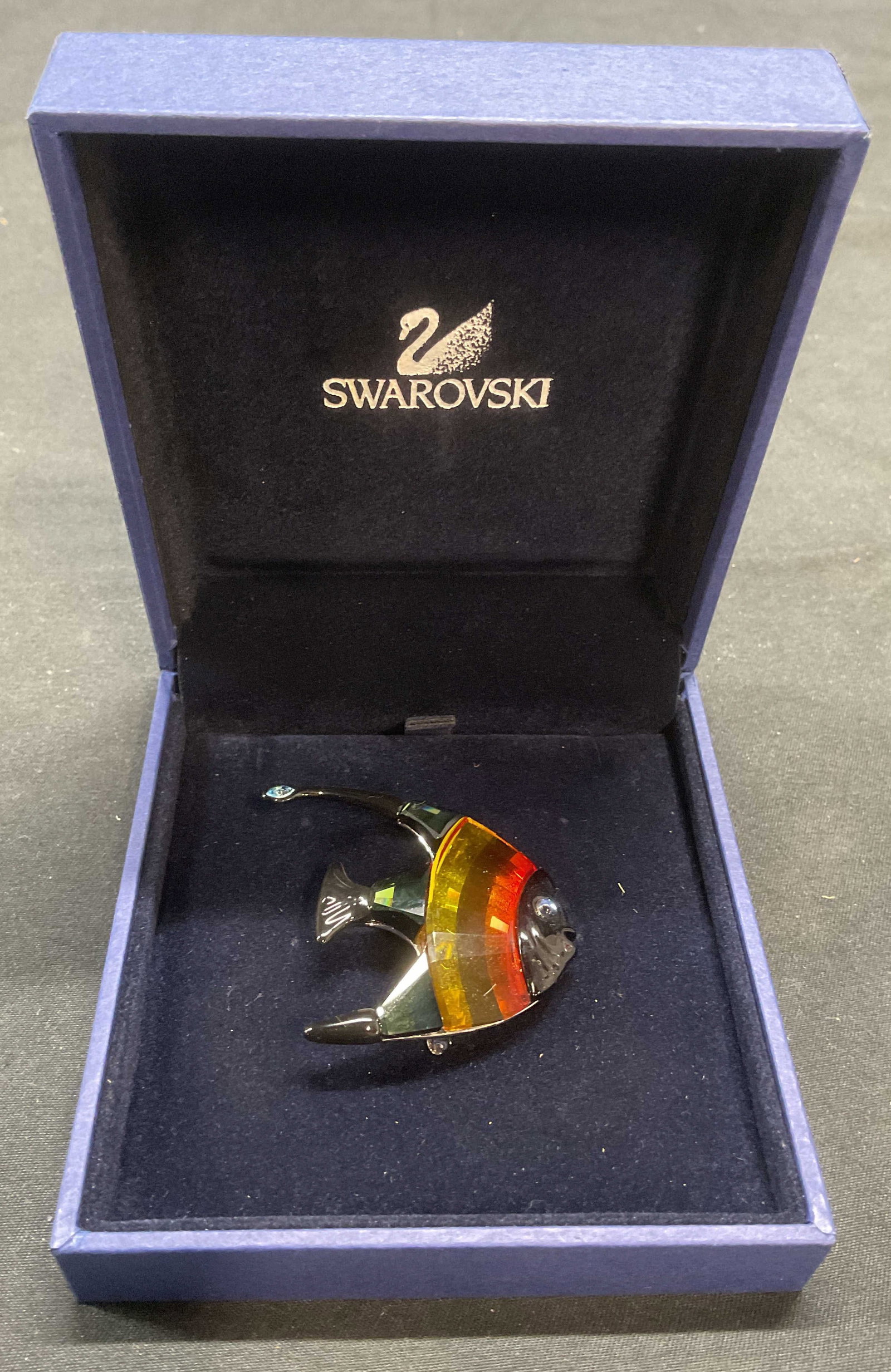 Swarovski Crystal Calabar Angelfish Brooch: Swarovski Calabar Angelfish brooch. Cut Crystal in hues of green, yellow, orange and black. Measures approx. 1.5 x 1.5 inches. Signed on underside. Hinge pin on underside. Includes original jewelry bo
