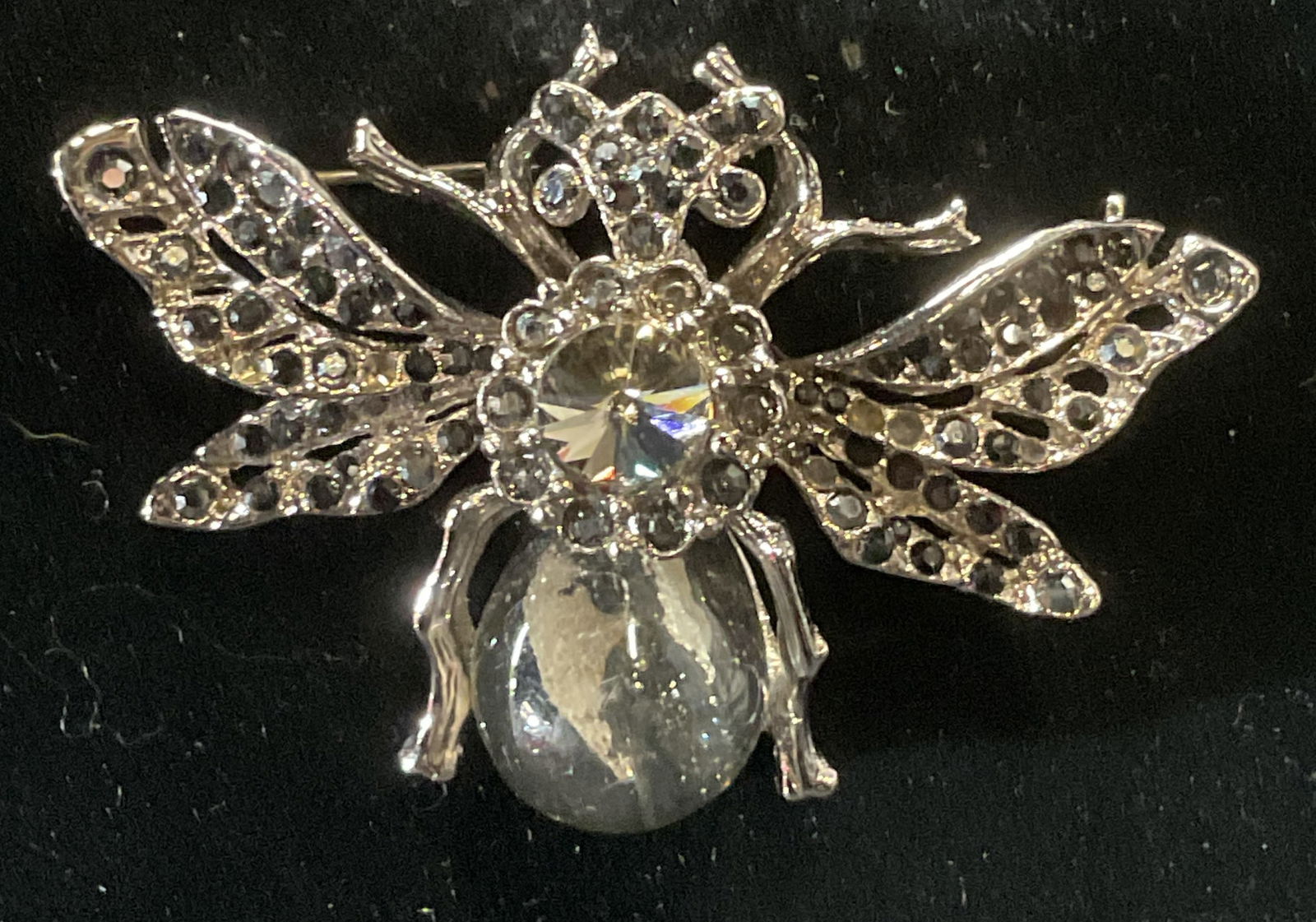 Silver Tone Crystal Fly Insect Brooch: Silver tone fly insect motif brooch with crystal and lucite decoration. Hinge pin to underside. Measures approx. 1.5 x 2.25 inches. Some surface wear including scratching observed. Some crystals need