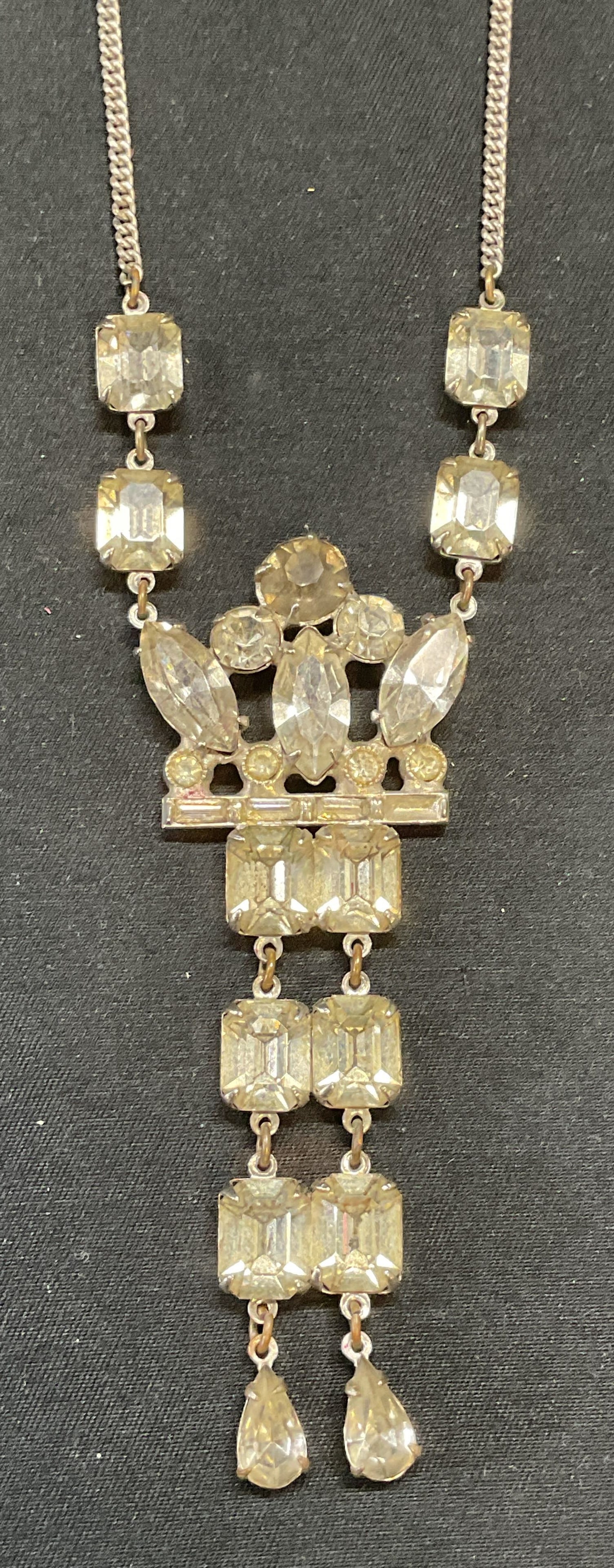 Vintage Silver Tone Crystal Pendant Necklace: Vintage silver tone necklace with colorless crystal decorated pendant. Drop length approx. 9.5 inches. Pendant measures approx. 3.5 inches long. Clasp marked sterling only. Some surface wear including