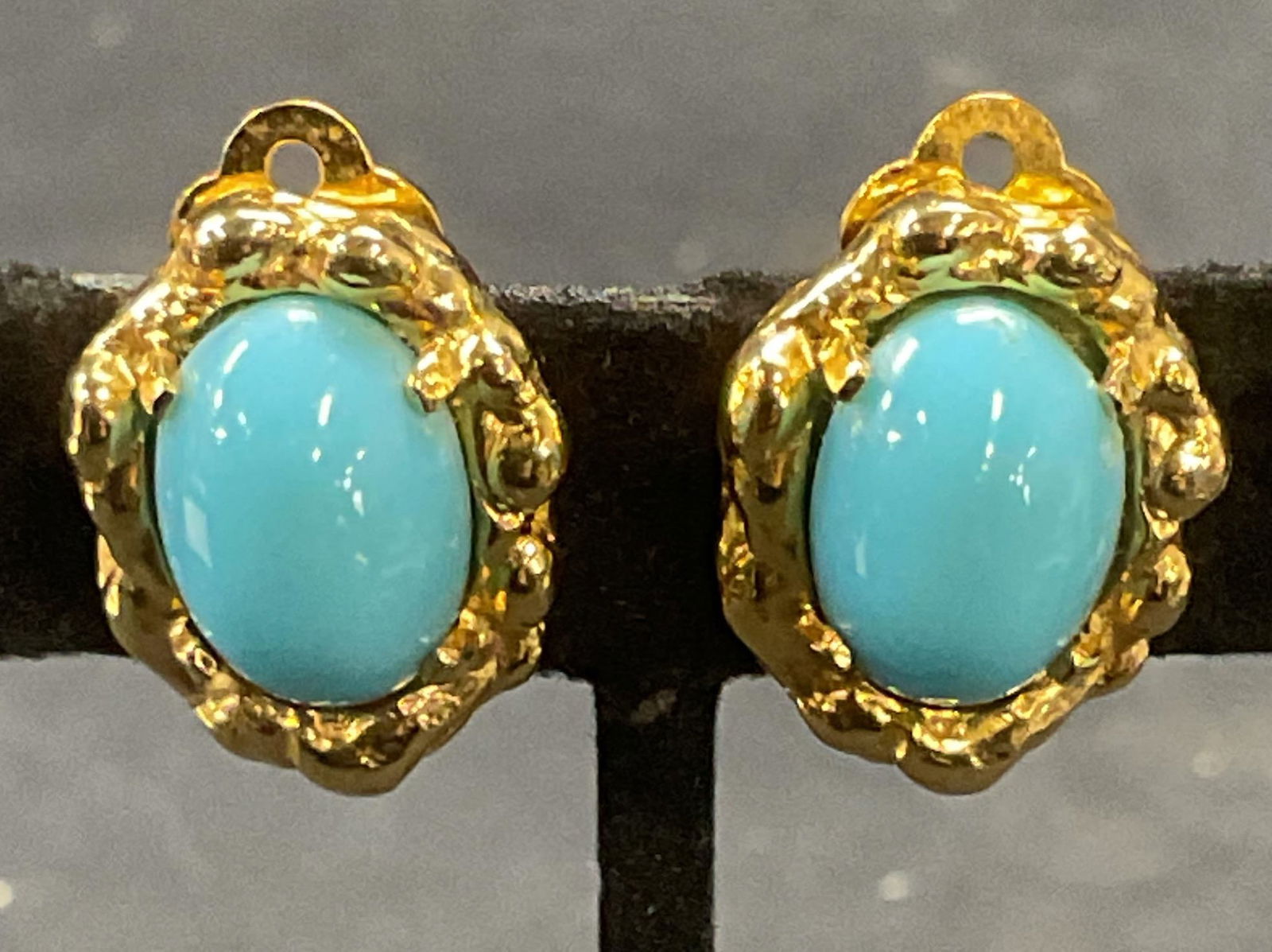 Vintage Jomaz Gold Tn Turquoise Cabochon Earrings: Vintage Jomaz Joseph Mazer gold tone clip on earrings with turquoise cabochon decoration. Signed on underside. Measure approx. .75 x .5 inches. Some surface wear including scratching observed. Jewelry