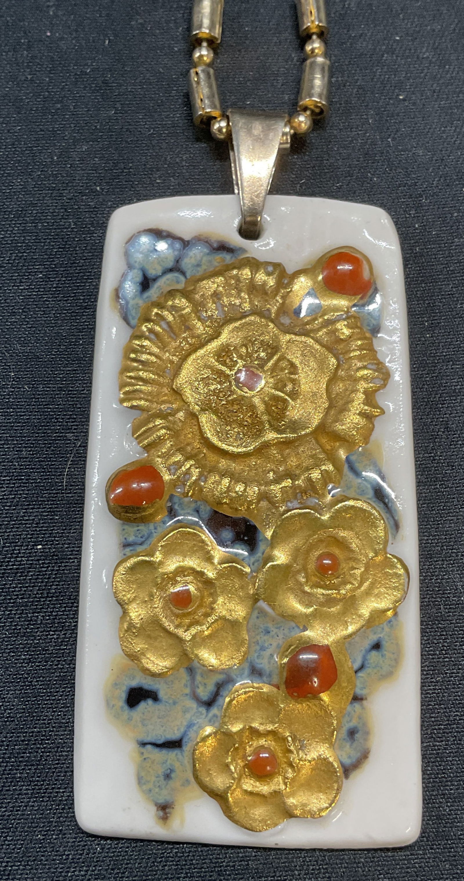 Mid Century Royal Copenhagen Pendant Necklace: Vintage mid century Royal Copenhagen Nils Thorsson porcelain pendant with floral motif. Gilt and hand painted decoration. Signed to underside. Made in Denmark. Includes gold tone chain. Pendant measur