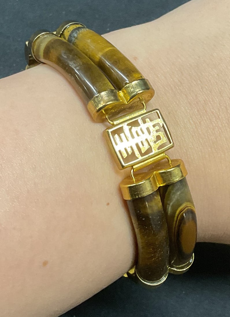 Gold Tn Tigers Eye Asian Motif Bracelet: Gold tone Asian motif bracelet with tigers eye gemstones. Possibly gold plated or filled. Measures approx. 8 inches long. Some surface wear including scratching observed. Jewelry, estate jewelry, fine