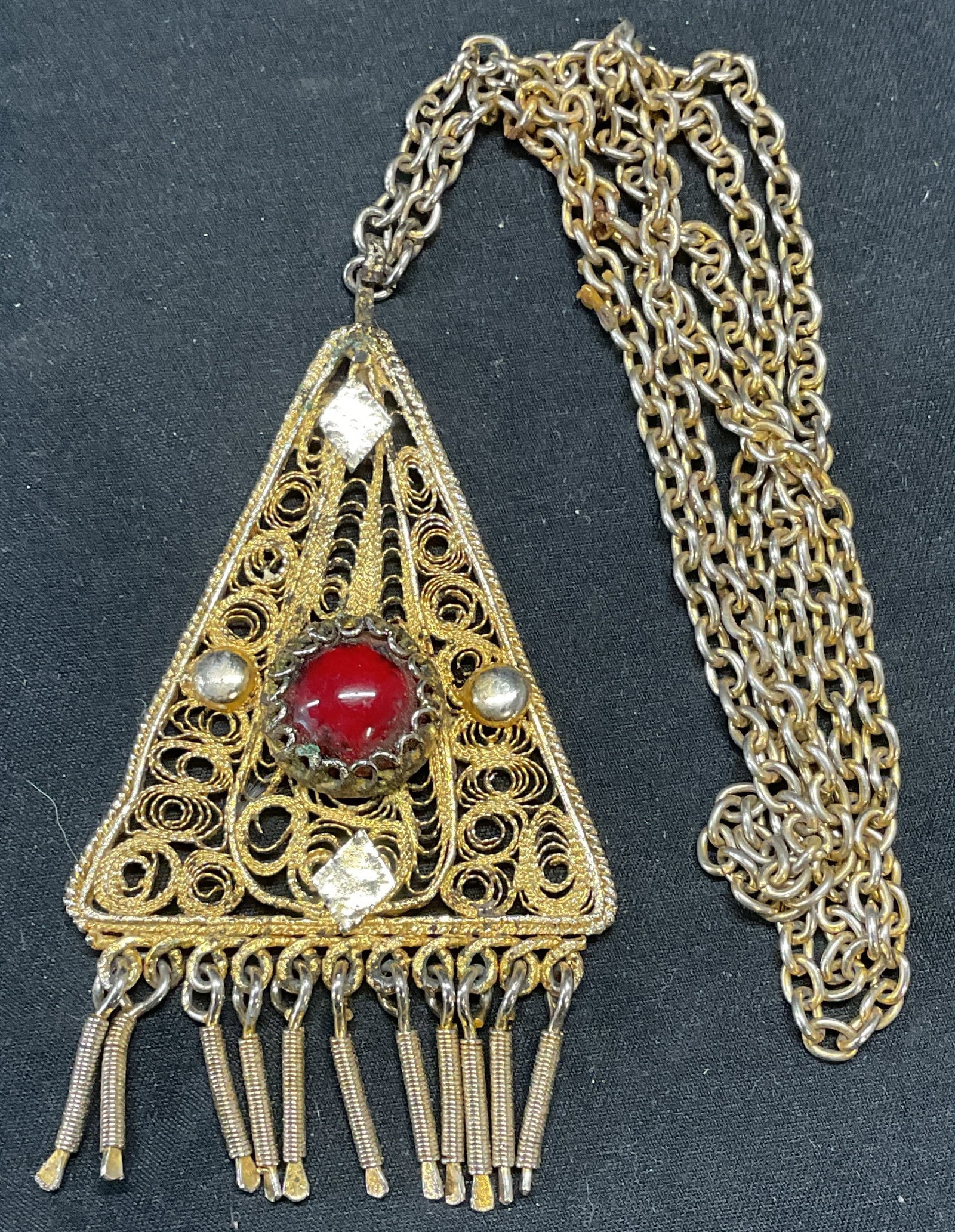 Vintage Gold Tone Red Cabochon Necklace: Vintage gold tone necklace with filigree detail pendant and red cabochon decoration. Drop length approx. 15 inches. Pendant measures approx. 3 inches long. Some surface wear including scratching obser