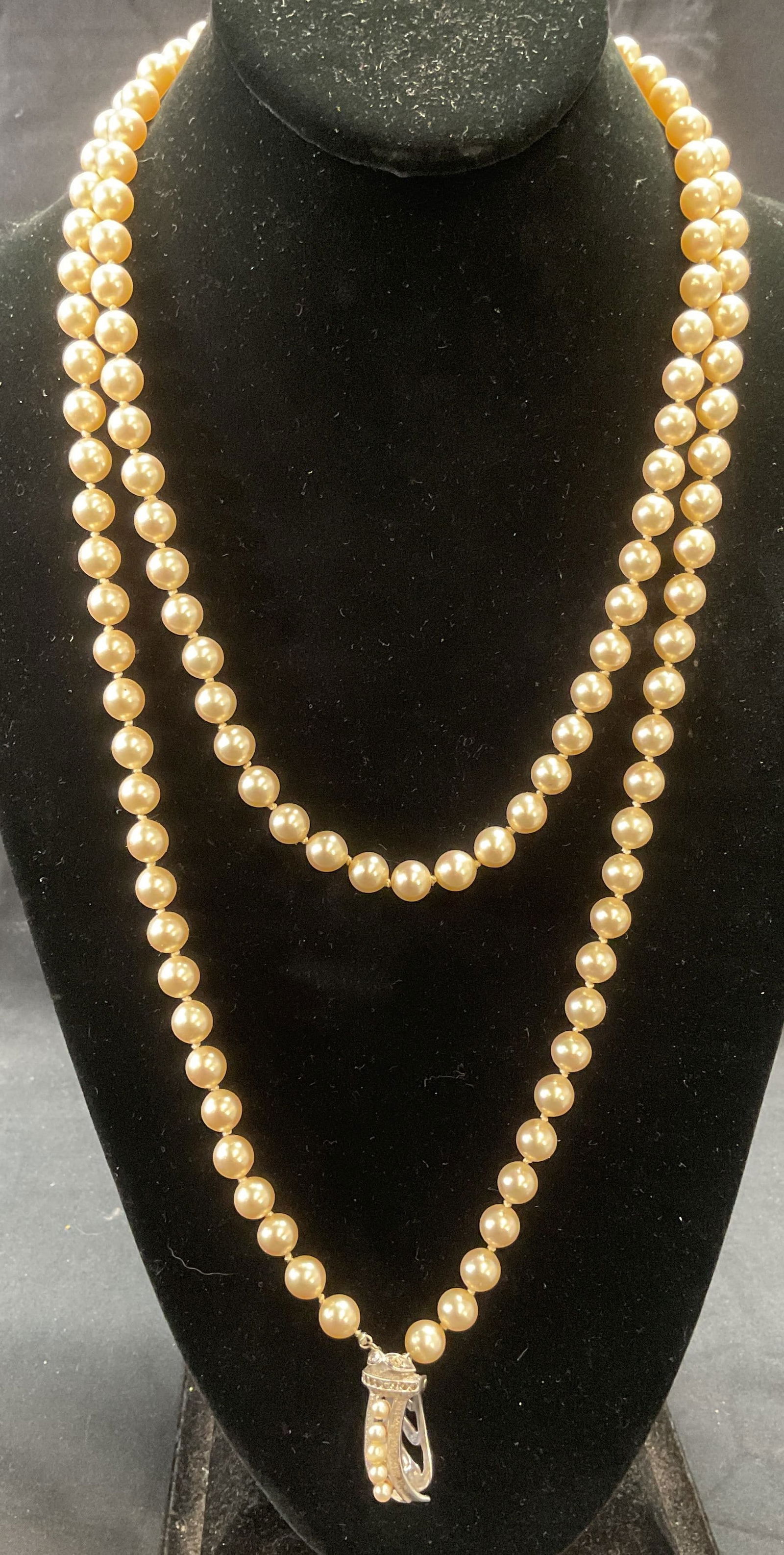 Vintage Majorica Faux Pearl Beaded Necklace: Vintage Majorica faux pearl beaded pendant necklace on double knotted string. Silver tone clip pendant. Signed on pendant. Drop length approx. 24 inches. Pendant measures approx. 1 inch long. Some sur