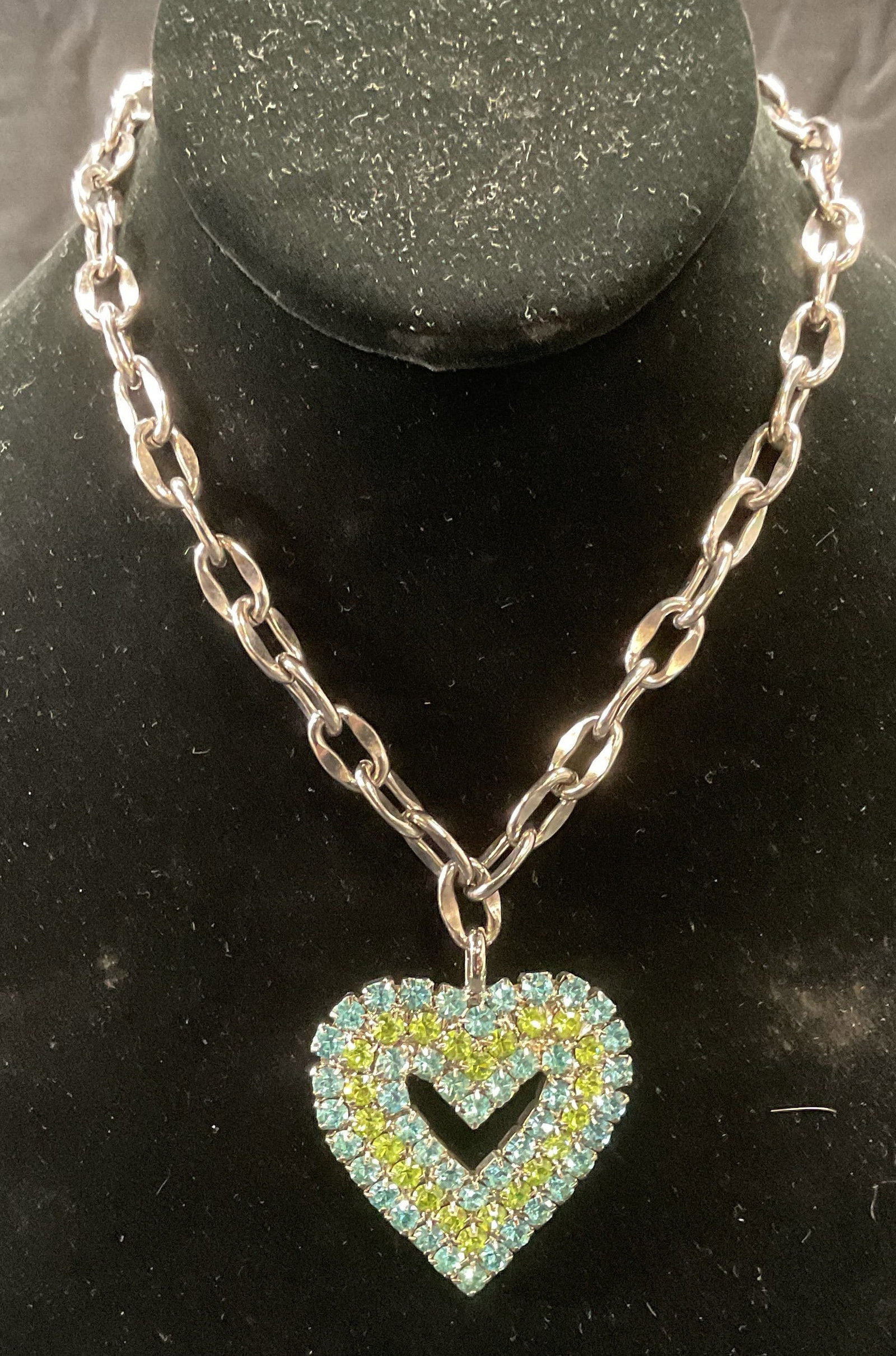 Tarina Tarantino Swarovski Crystal Heart Necklace: Tarina Tarantino silver tone pendant necklace with heart shaped Swarovski crystal decorated pendant in blue and green. Signed on pendant. Drop length approx. 7.5 inches. Pendant measures approx. 2 x 1
