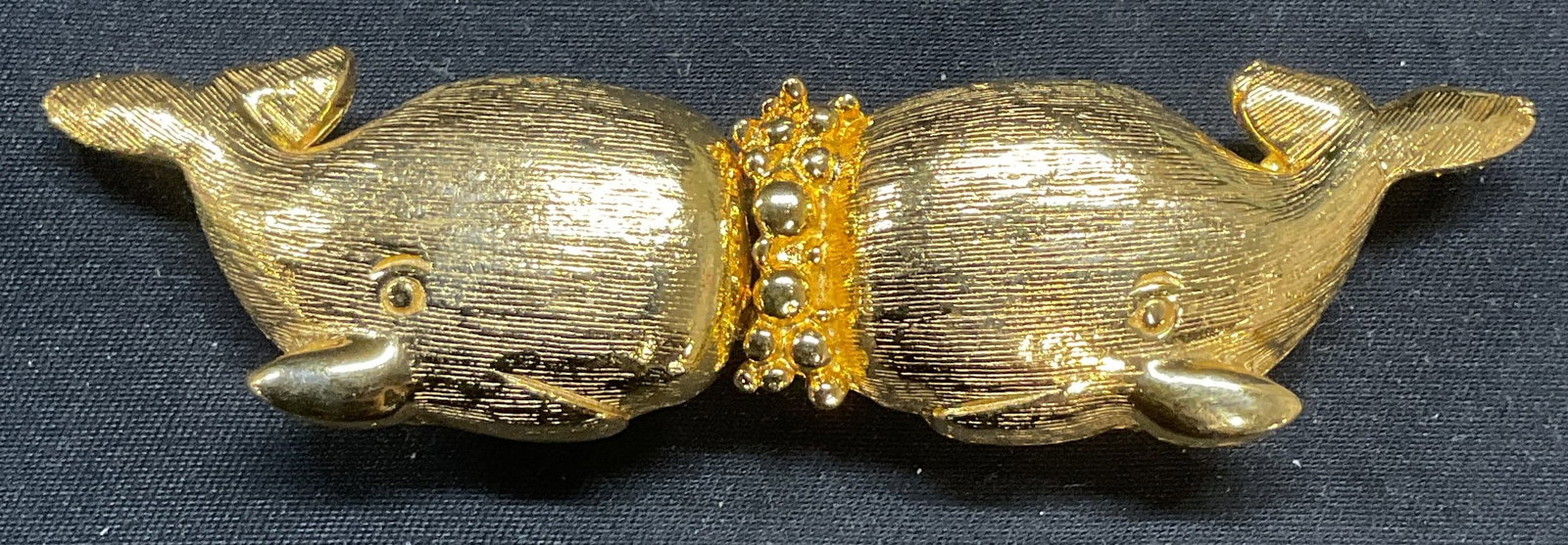 Vntg Jeanine Bouchever Gold Tn Whale Belt Buckle: Vintage Jeanine Bouchever brushed gold tone whale motif belt buckle. Two pieces. Signed to underside. Larger piece measures approx. 2 x 1 inches. Some surface wear including scratching observed. Jewel