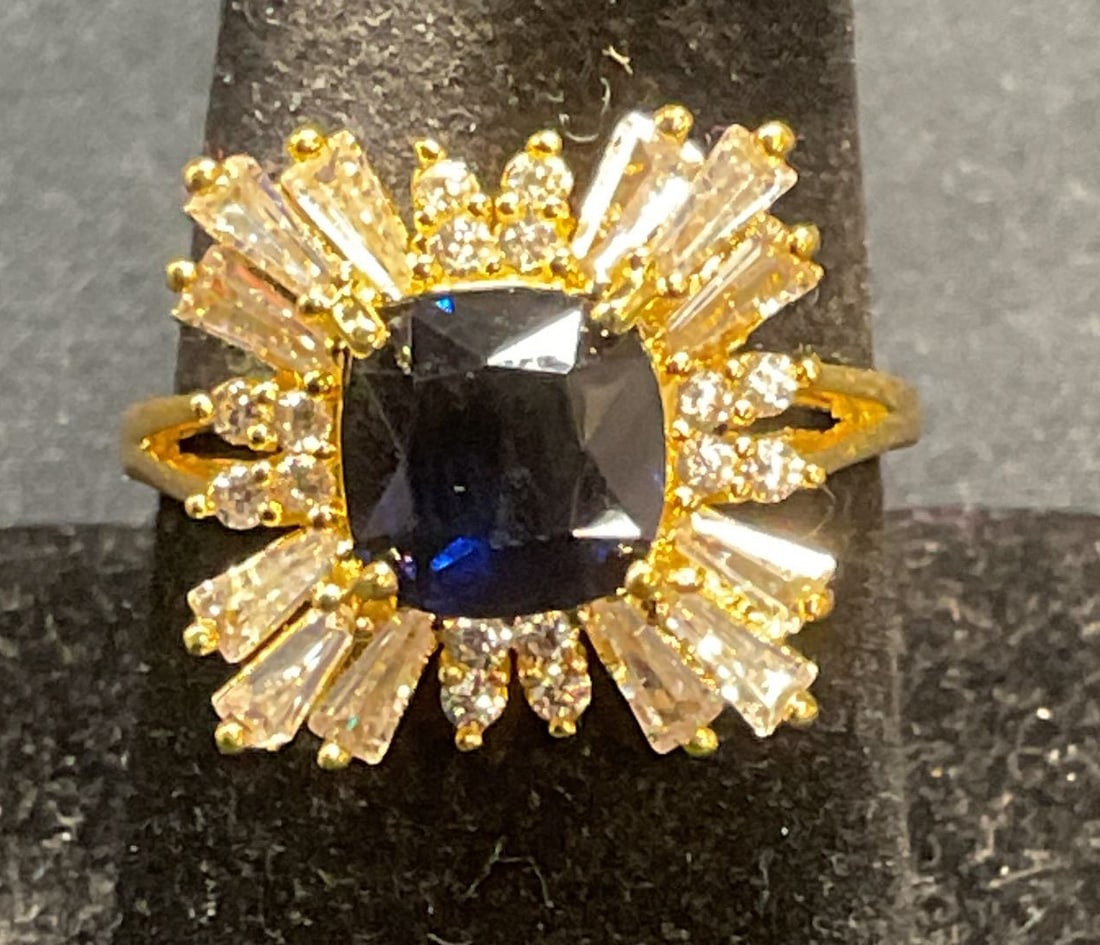 Gold Tone Blue Crystal Cocktail Ring: Gold tone ring with blue and colorless crystal decoration. Ring size 8.25. Some surface wear including scratching observed. Jewelry, estate jewelry, costume jewelry, cocktail jewelry, fashion jewelry,