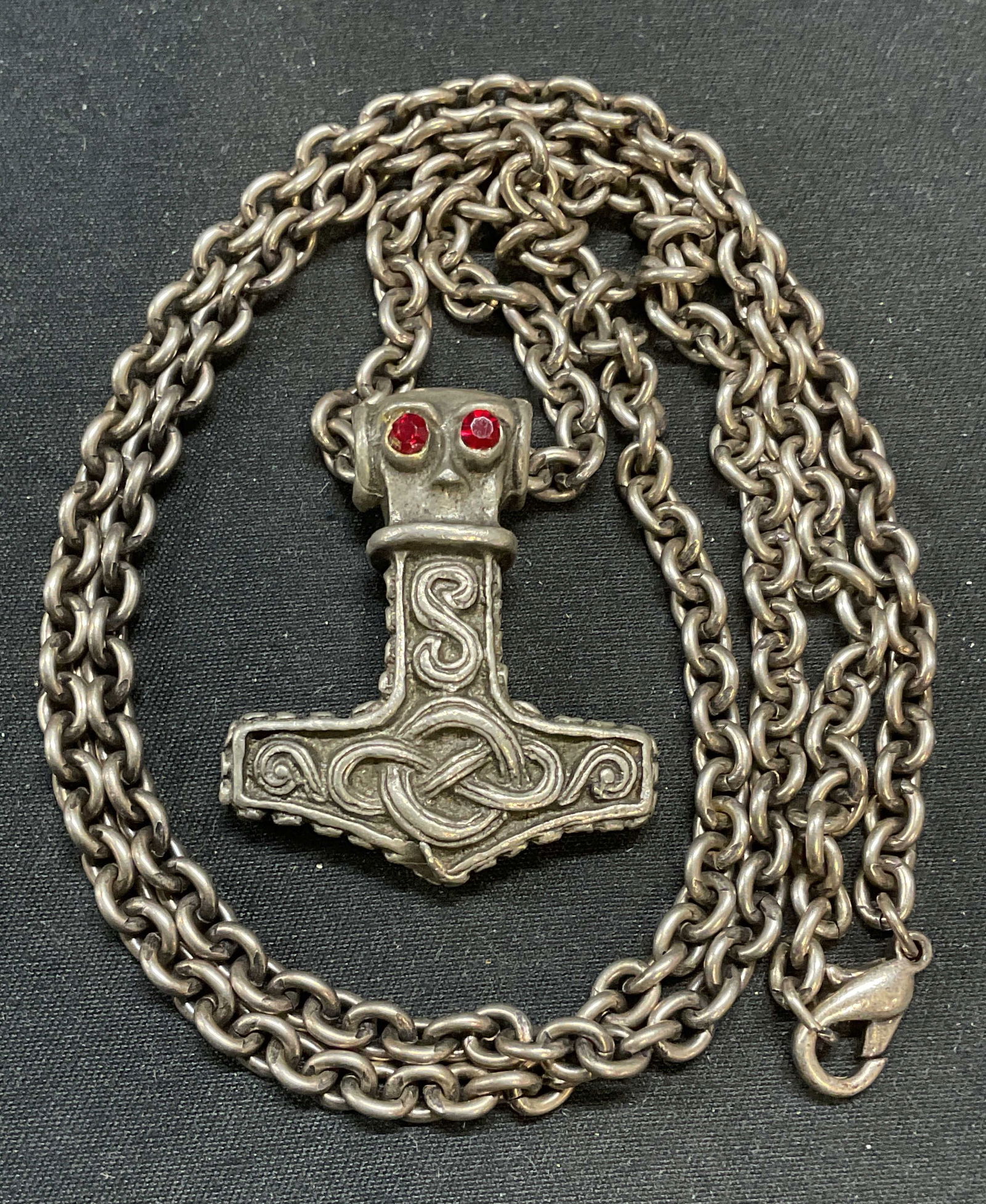 Silver Tn Mjolnir Thor Hammer Pendant Necklace: Silver tone, possibly pewter, pendant necklace. Norse Mjolnir hammer of Thor motif. Red crystal detail. Drop length approx. 14.5 inches. Pendant measures approx. 1.5 x 1.25 inches. Some surface wear i