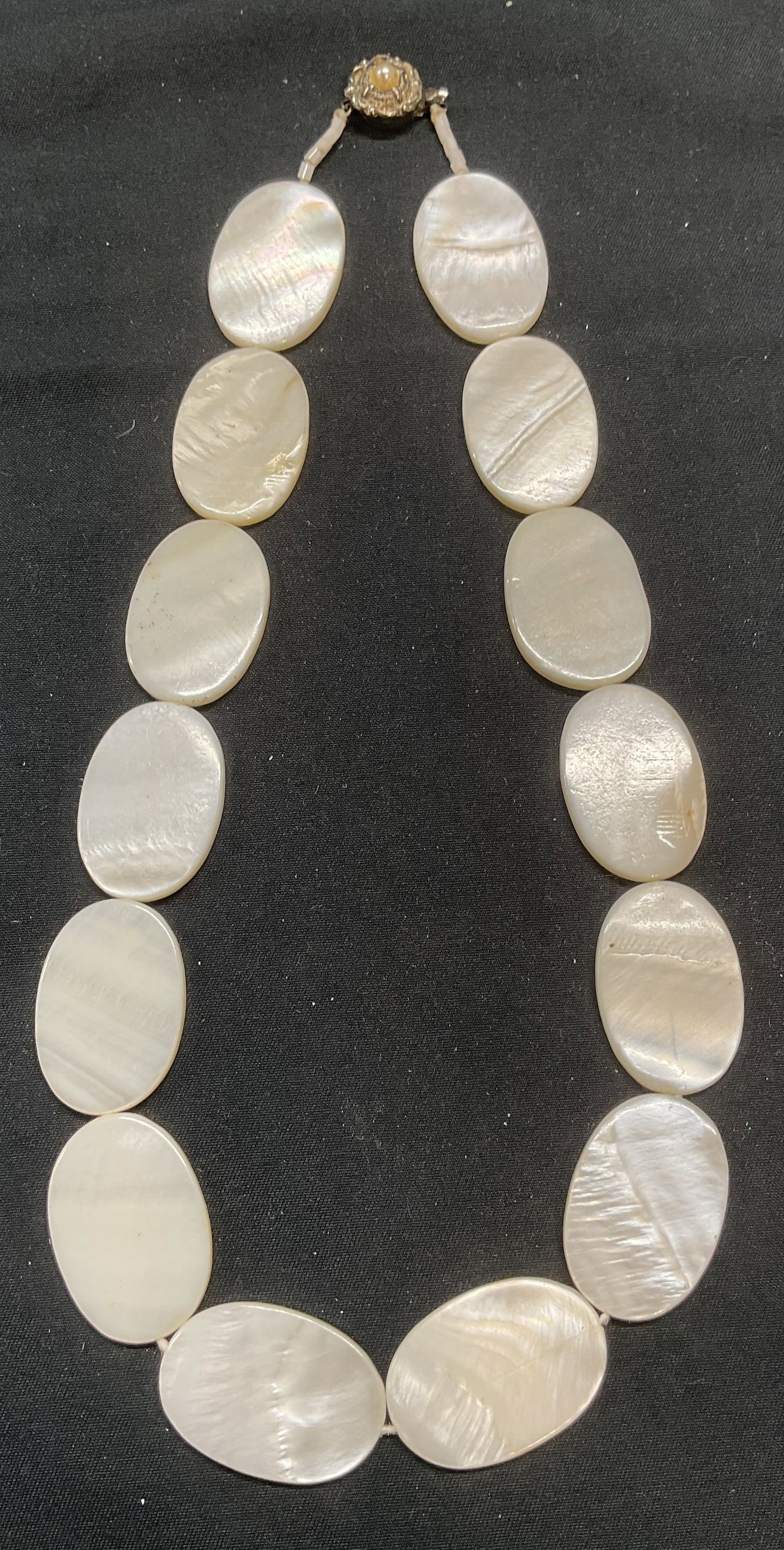 Vintage Mother of Pearl Medallion Necklace: Vintage necklace with mother of pearl medallion beads. Silver tone faux pearl decorated clasp. Drop length approx. 7.5 inches. Some surface wear including scratching observed. Jewelry, estate jewelry,