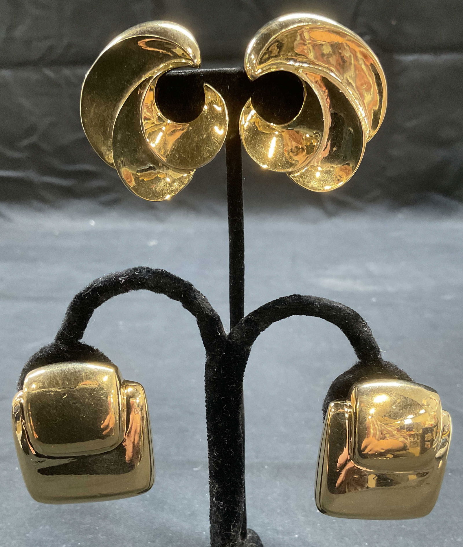 Lot 2 Vntg M. J. Ent Gold Tone Swirl Earrings +: Lot of 2 jewelry pieces. Vintage M. J. Ent gold tone swirl motif clip on earrings. Signed on underside. Measure approx. 1.5 inches wide. Vintage gold tone square clip on earrings. Style of Laura BIAGI