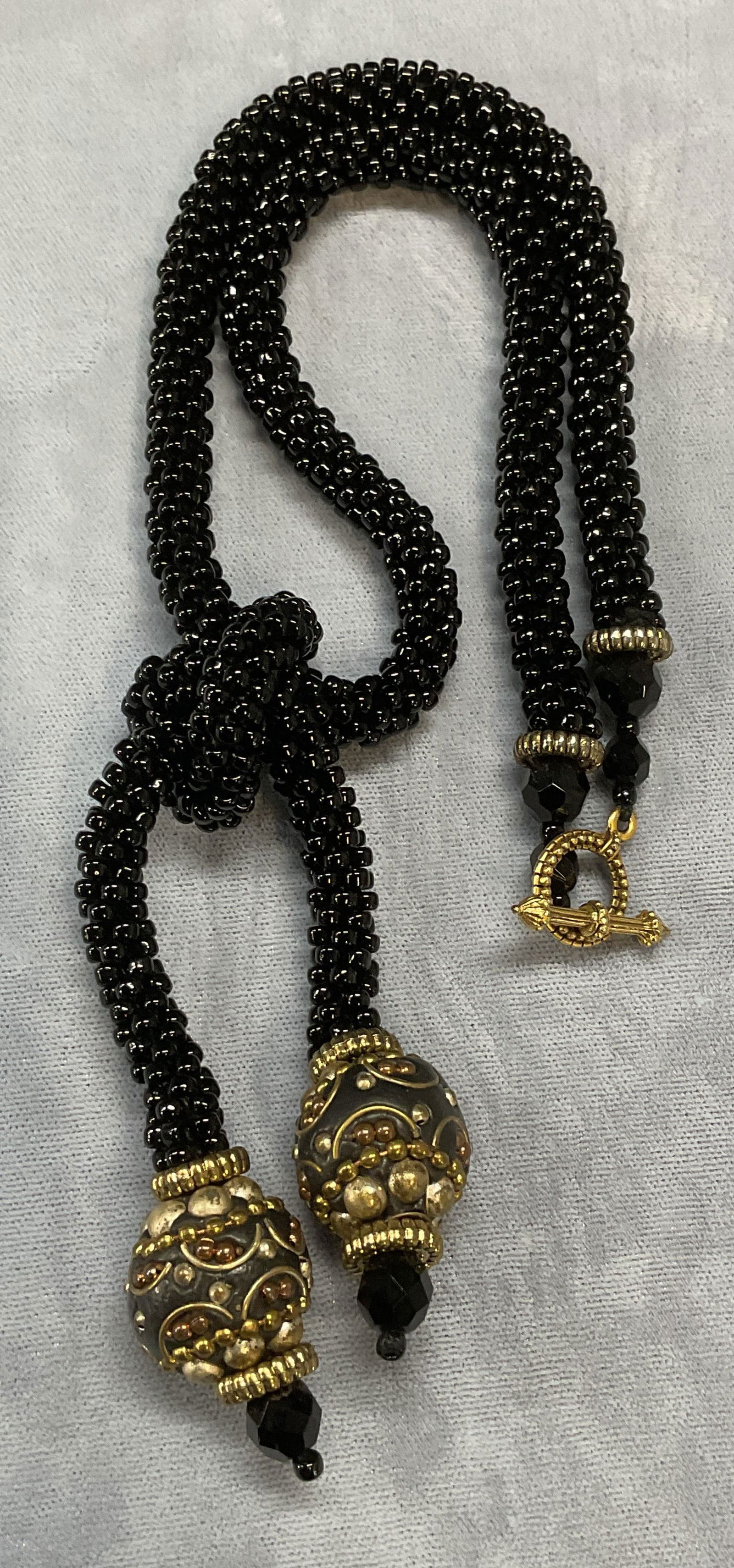 Black Seed Beaded Pendant Necklace: Black seed beaded pendant necklace its silver and gold tone raised bead decoration. Drop length approx. 8 inches. Some surface wear including scratching observed. Jewelry, estate jewelry, costume jewe