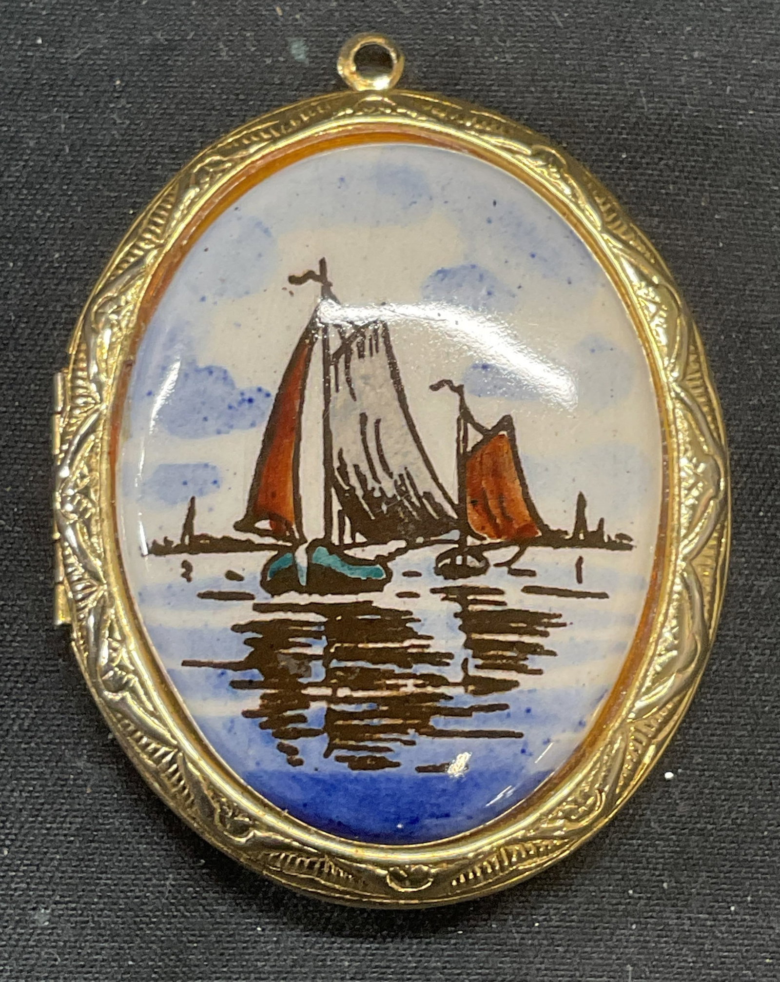 Gold Tone Sailboat Motif Locket Pendant: Gold tone locket pendant with enamel sailboat motif. Measures approx. 1.75 x 1.5 inches. Some surface wear including scratching observed. Jewelry, estate jewelry, costume jewelry, cocktail jewelry, fa