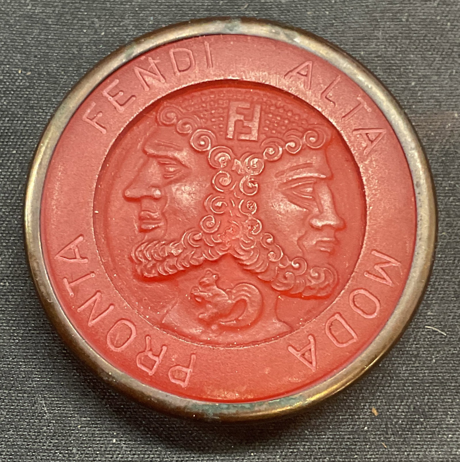 FENDI Alta Moda Pronta Red Figural Button: FENDI red and silver tone figural relief button or pendant. Reads FENDI Alta Moda Pronta with two male figures. Measures approx. 1.5 inches diameter. Some surface wear including scratching observed. J