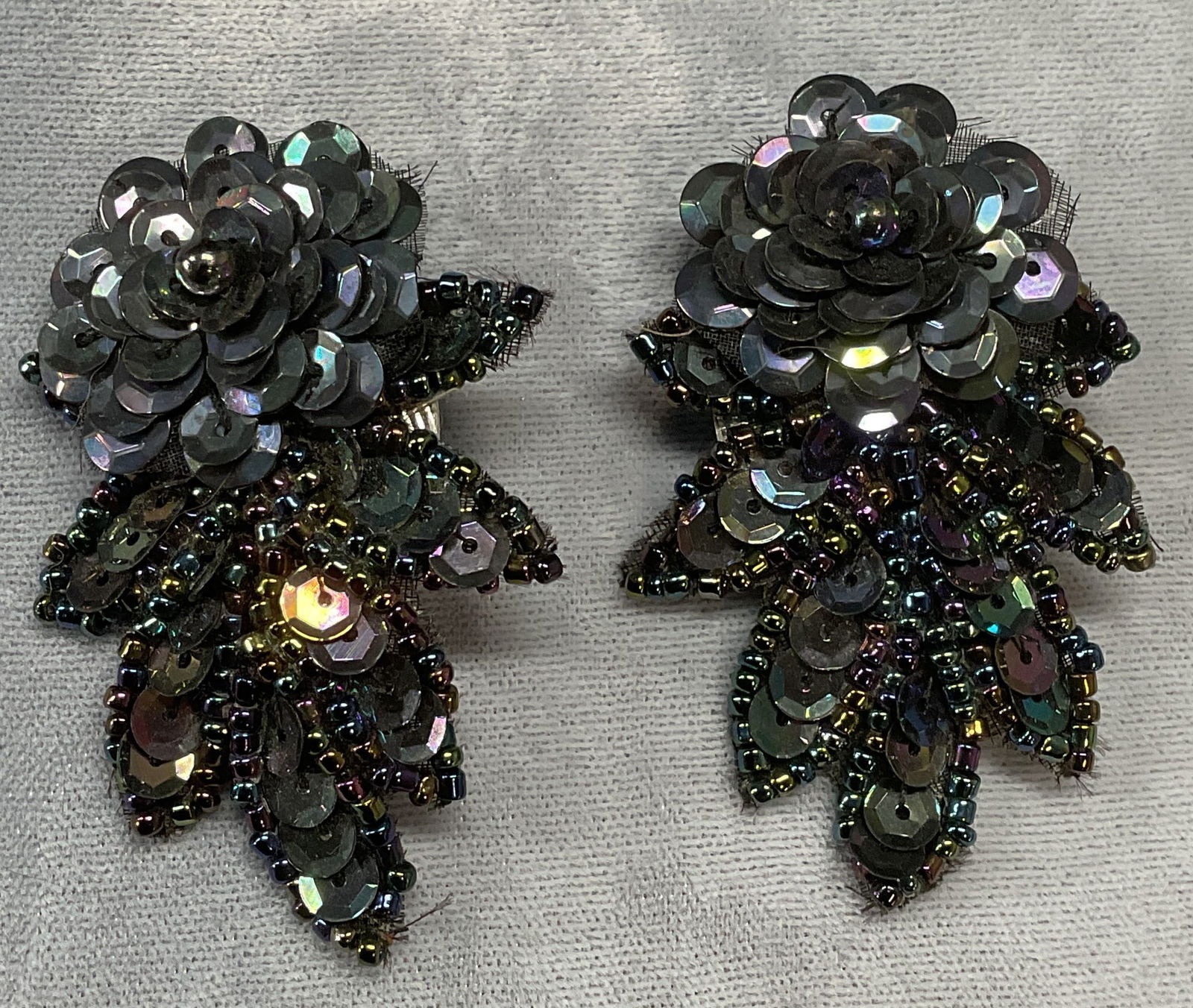Black & Purple Sequin Flower Earrings: Black and purple toned sequin and beaded flower motif earrings. Post backing. Measure approx. 2 x 1.5 inches. Some surface wear including scratching observed. Jewelry, estate jewelry, costume jewelry,