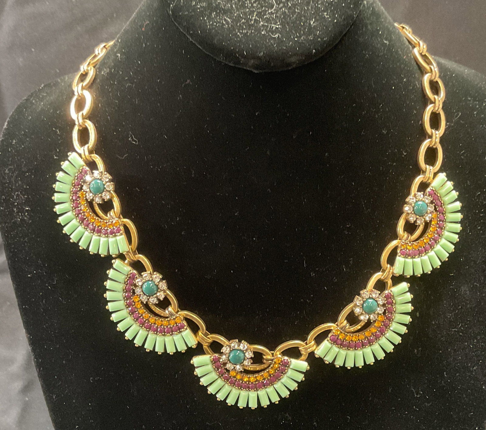 J Crew Gold Tone Crystal Choker Necklace: J Crew gold tone choker necklace with multicolor crystal and cabochon decoration. Hues of green, purple, and orange. Signed on hang tag. Drop length approx. 9 inches. Necklace has weight. Some surface