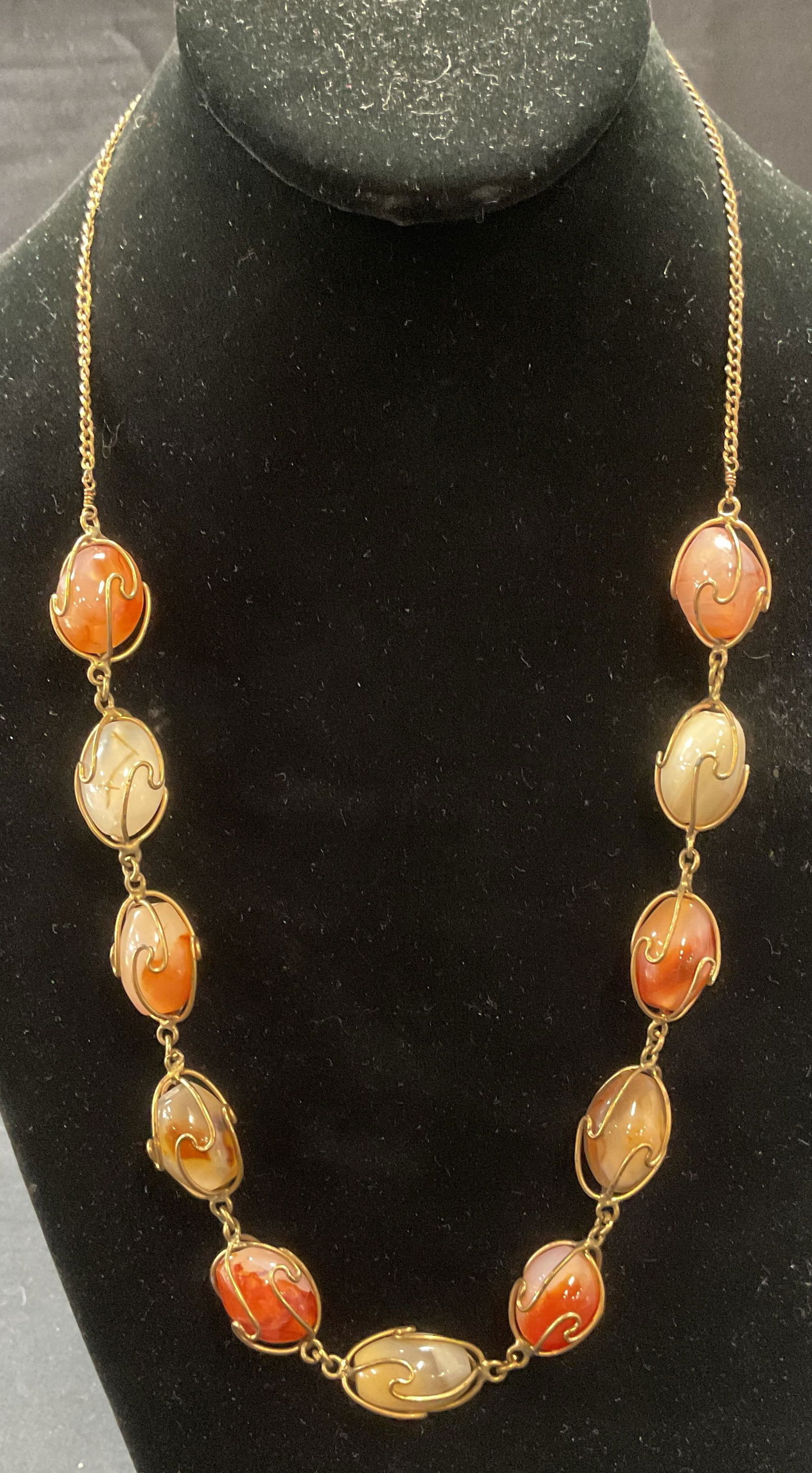 Vintage Gold Tone Orange Agate Necklace: Vintage gold tone chain and wire necklace with orange and white toned agate gemstones. Drop length approx. 11.5 inches. Total weight 65.5 grams. Some surface wear including scratching observed. Jewelr