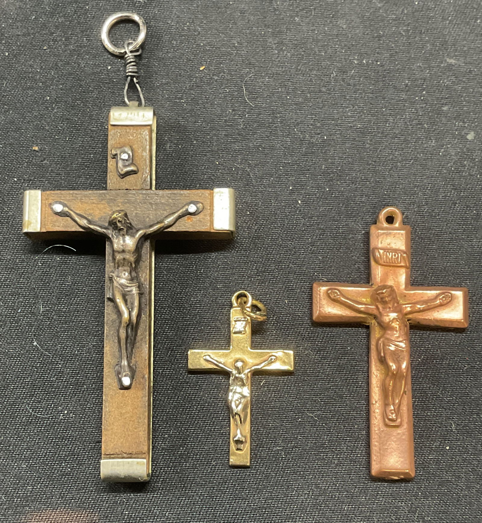 Lot 3 Wood, Copper, Gold Tn Crucifix Pendants: Lot of 3 vintage wood, copper, and gold tone crucifix pendants. Wood crucifix marked made in Italy, Roma. Copper pendant signed illegibly. Gold tone pendant marked illegibly. Largest measures approx.