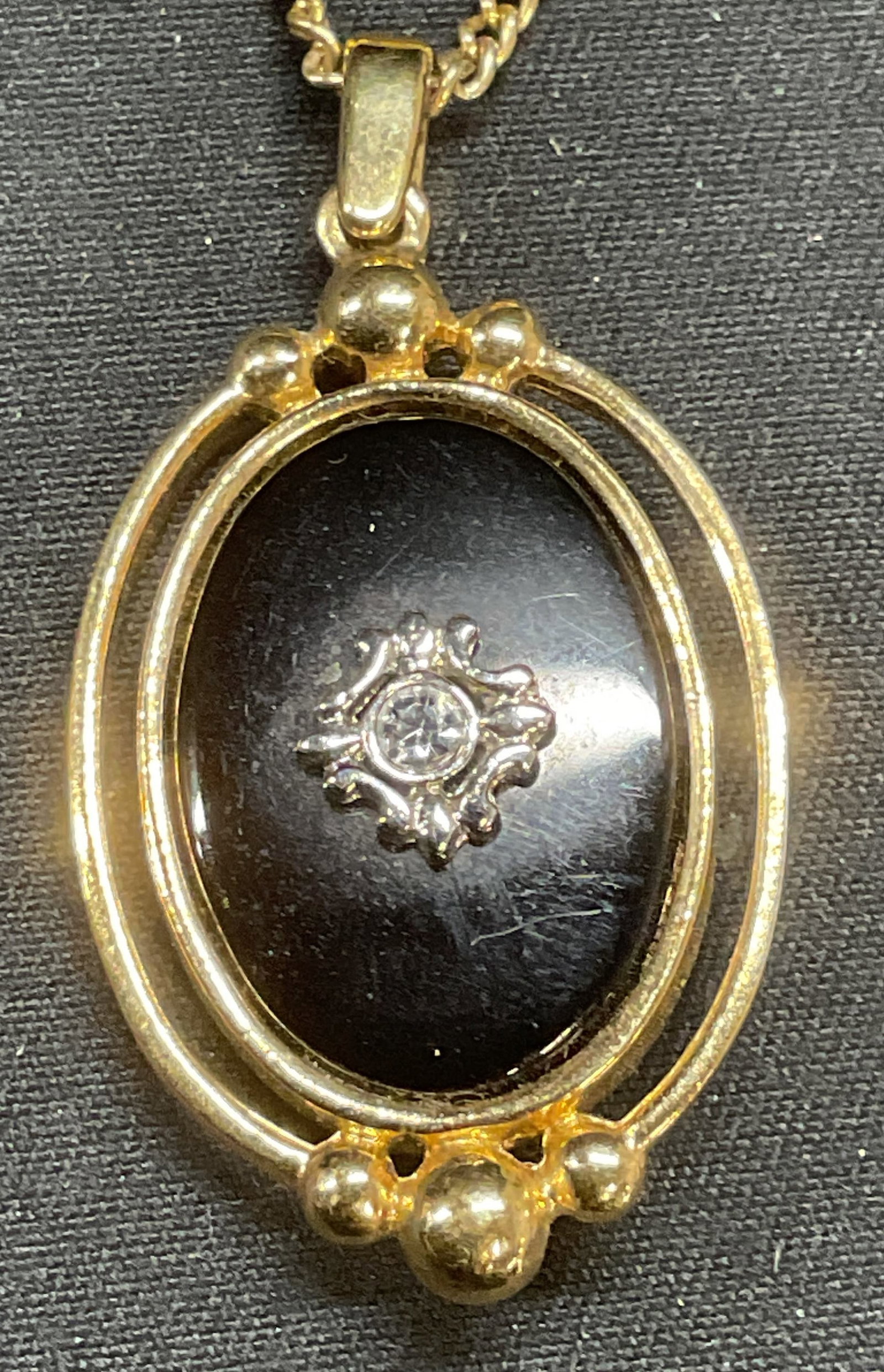 Gold Tone Black Cabochon Crystal Pendant Necklace: Gold tone pendant necklace with black coach on and colorless crystal decoration. Drop length approx. 8 inches. Pendant measures approx. 1.25 inches long. Some surface wear including scratching observe
