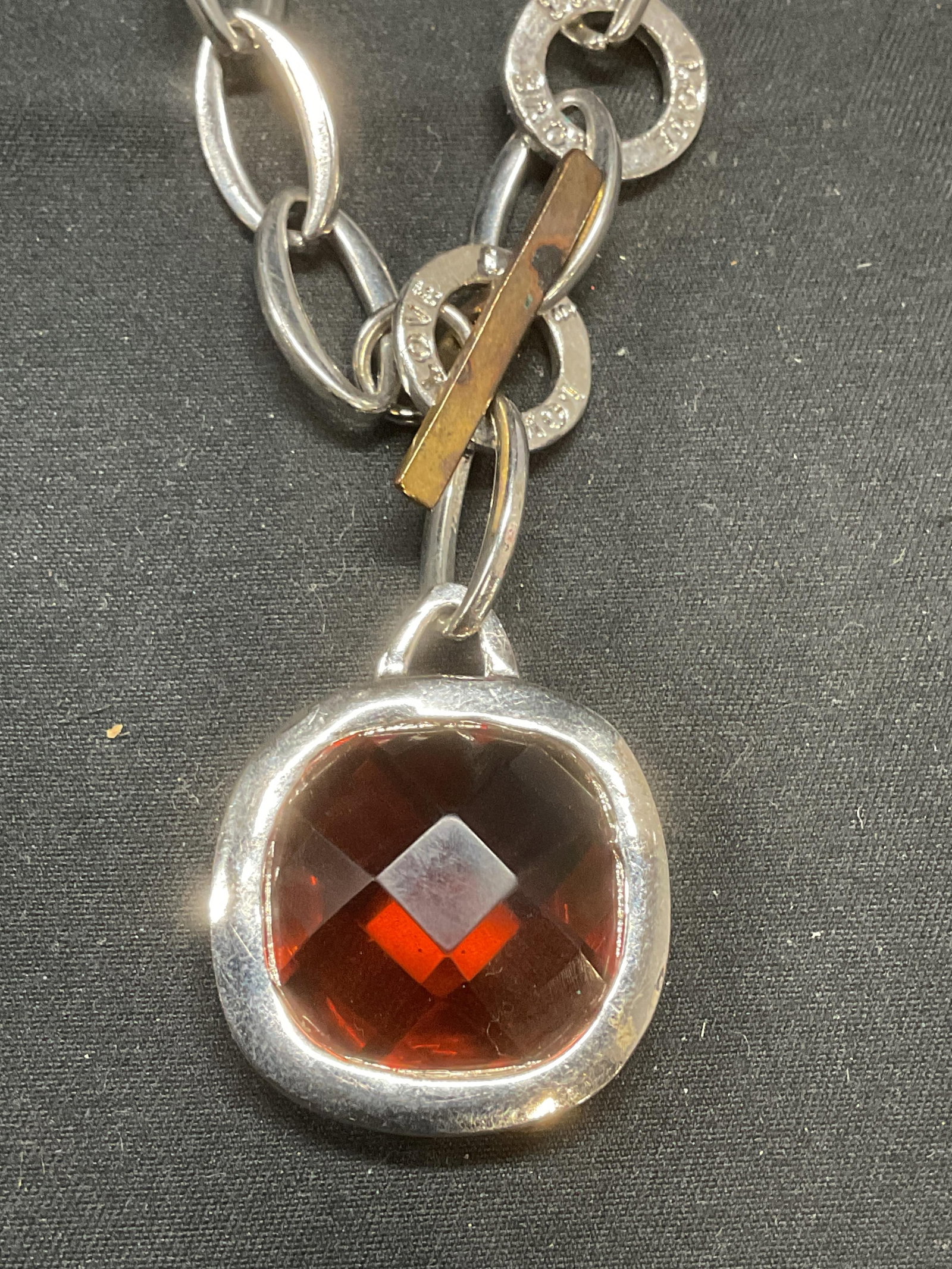 Silver Tone Red Crystal Pendant Necklace: Silver tone red crystal pendant necklace. Reads Love on clasp. Drop length approx. 8.5 inches. Pendant measures approx. 1 x 1 inches. Some surface wear including scratching observed. Jewelry, estate j