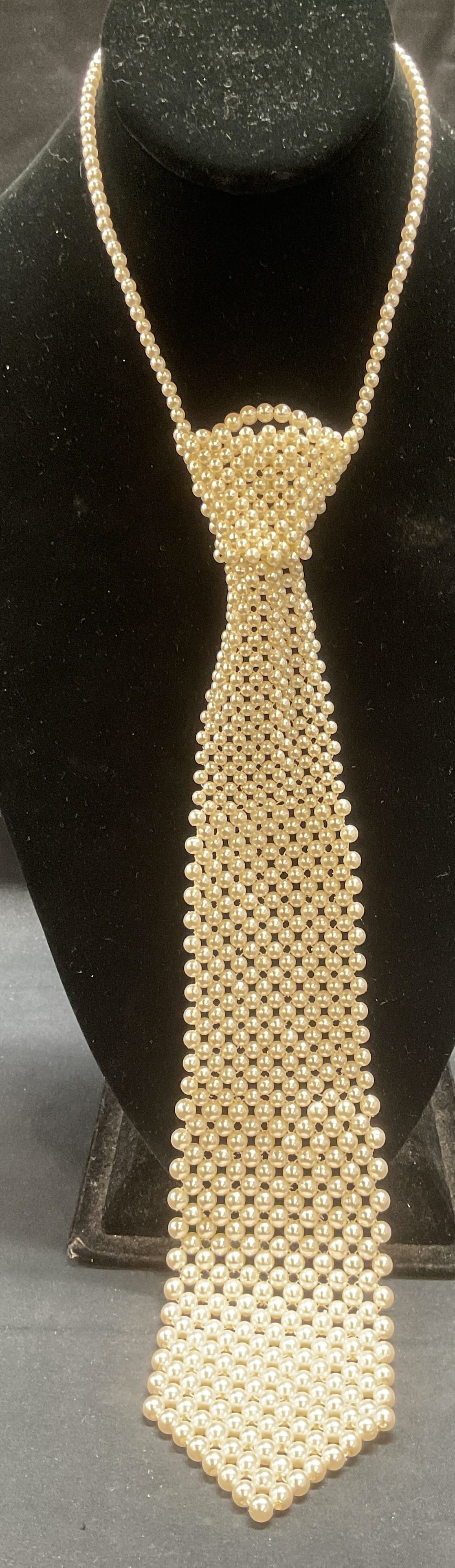 Faux Pearl Beaded Tie Pendant Necklace: Faux pearl beaded necklace with tie motif pendant. Drop length approx. 6 inches. Tie measures approx. 12.5 x 2.5 inches. Some surface wear including scratching observed. Jewelry, estate jewelry, costu
