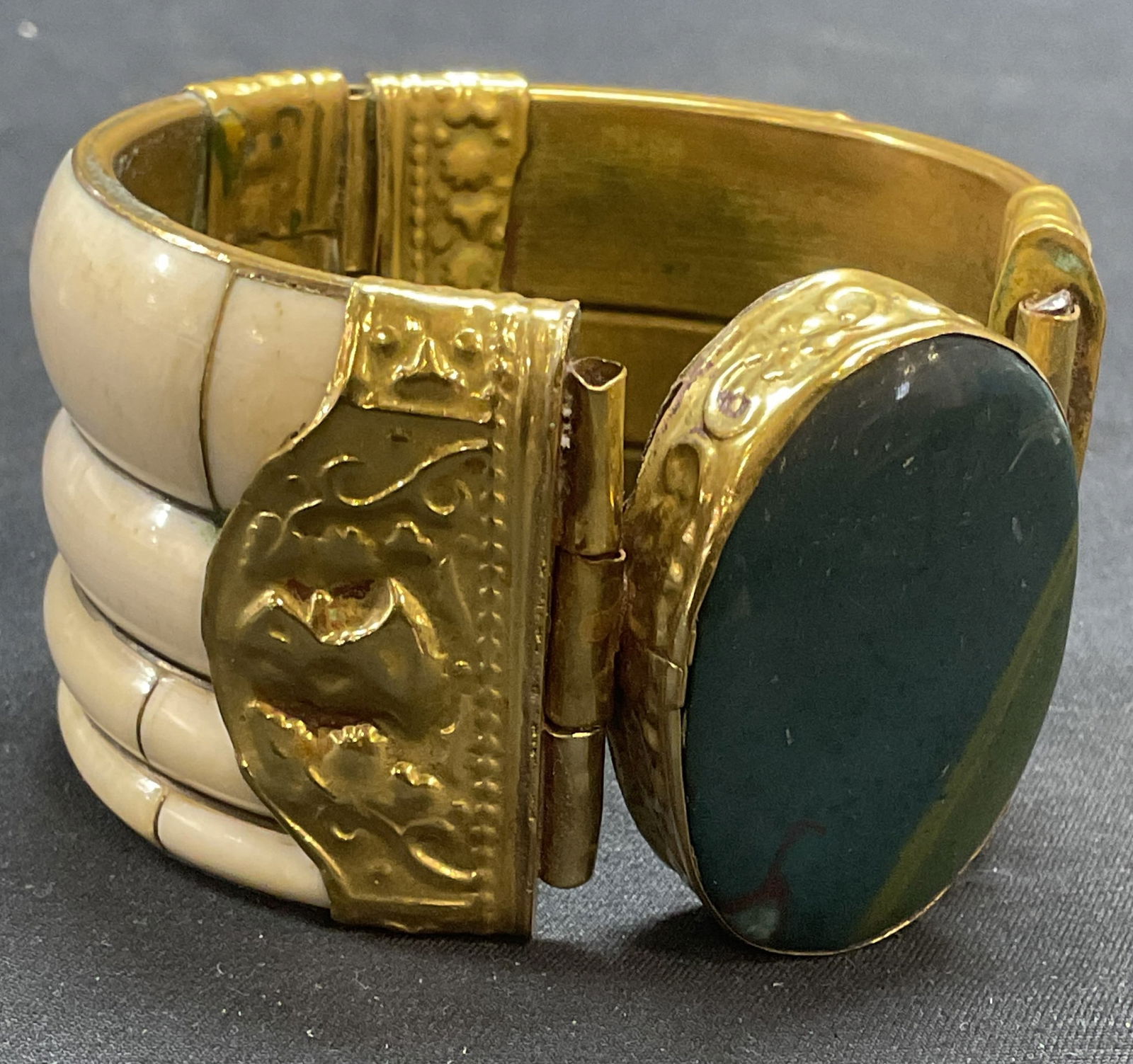 Vntg Handmade Gold Tn Bone & Stone Bracelet: Vintage handmade hinged bangle bracelet with embossed gold tone setting, bone, and multicolor blue natural stone. Measures approx. 2.5 inches wide, cuff approx. 1.75 inches wide. Some surface wear inc