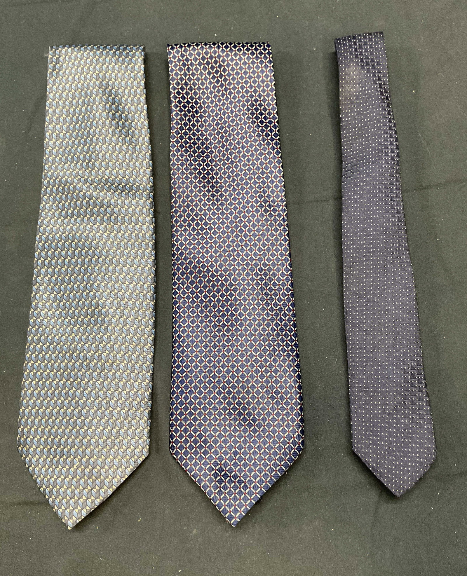 Lot 3 Romario Manzini Blue Patterned Ties & More: Lot of 3 blue patterned ties. 2 Romario Manzini blue ties. Polyester. 1 blue dot pattern tie. Rayon. Sizes vary, Romario Manzini ties measure approx. 57 inches long. All ties have some wear to materia