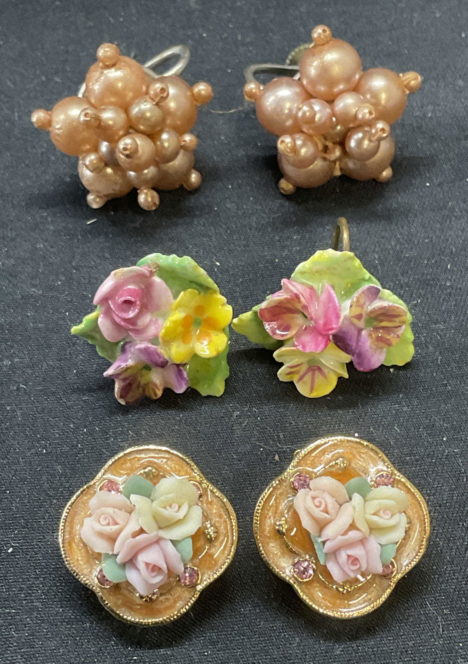 Lot 3 Vintage Flower & Faux Pearl Earrings: Lot of 3 pairs of vintage earrings. Faux pearl beaded earrings, enamel and porcelain flower motif earrings, and composite flower motif earrings. Clip on and screw backing. Largest pair measure approx.