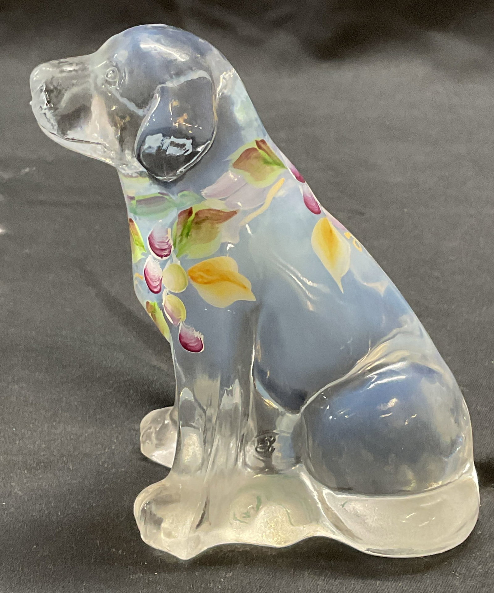 Fenton Kelley Art Glass Dog Figural: Fenton art glass dog figurine in clear Opaline glass. Hand painted floral motif. Signed by Fenton artist Kelley, stamped Fenton. Measures approx. 3.25 x 2.5 x 4.25 inches. Some surface wear including