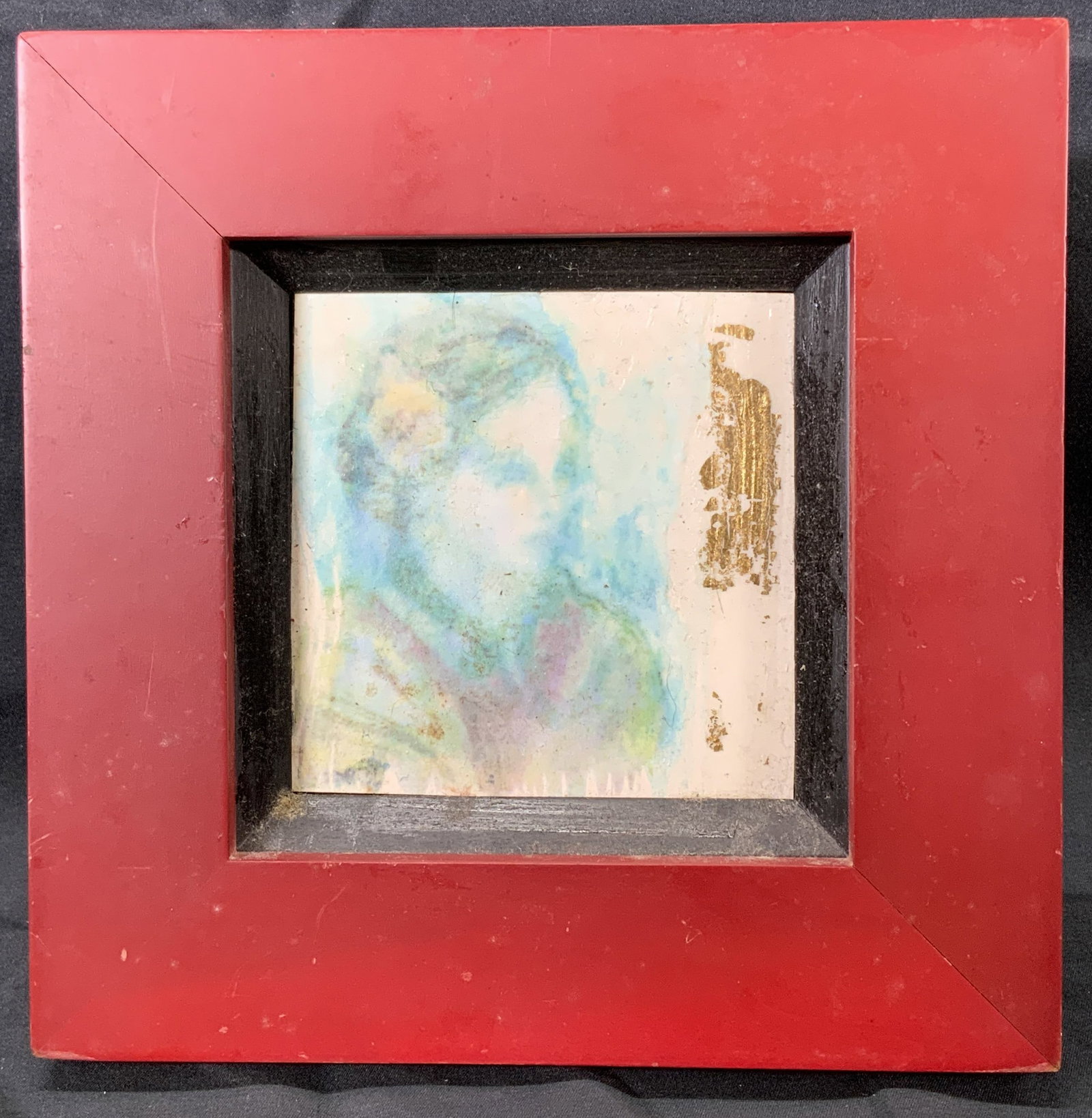Framed Watercolor Transfer Portrait of Young Woman: Watercolor transfer and gilt on gesso board. Subject depicts the portrait bust of a young woman with a flower in her hair. Strip of gilt on right side of board. Framed in red wooden frame. Frame measu