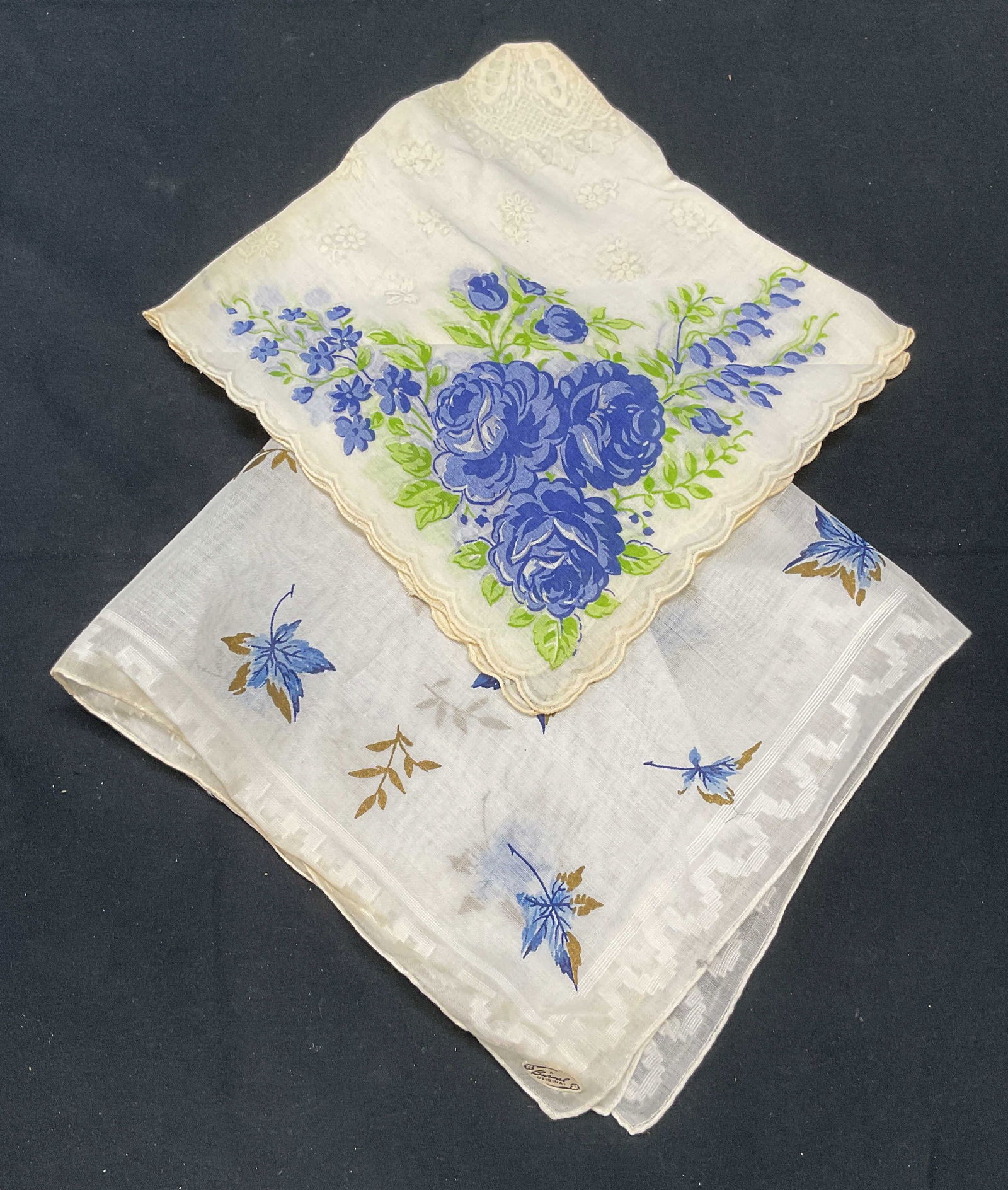 Lot 2 Vintage Burmel & Floral Handkerchiefs: Lot of 2 vintage handkerchiefs. 1 piece signed Burmel with leaf motif. 1 piece with floral motif. Materials feel like cotton or linen. Larger piece measures approx. 15 x 14 inches. Both pieces have so