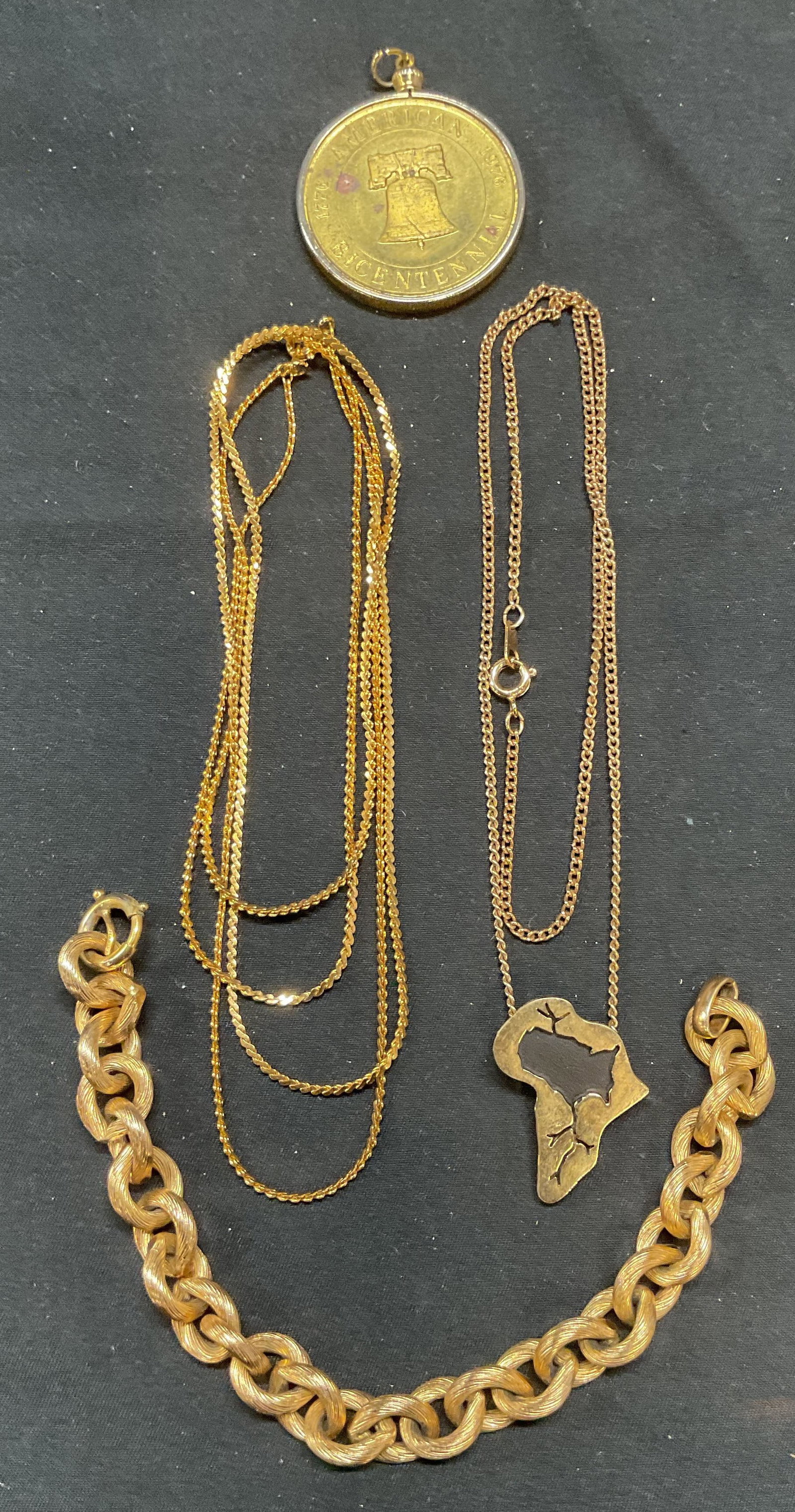 Lot 4 American Bicentennial Pendant +: Lot of 4 jewelry pieces. Gold tone American Bicentennial pendant with liberty bell Native American head motif. Measures approx. 1.5 inches diameter. Sala gold tone Africa continent motif pendant neckl