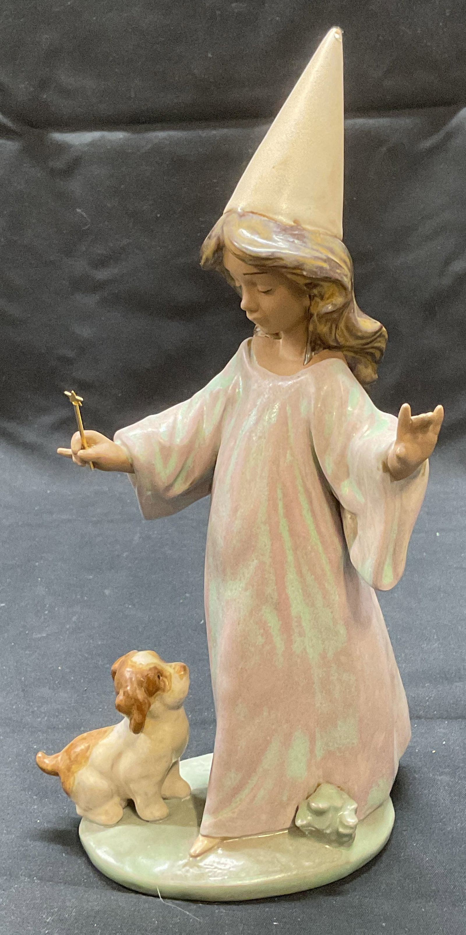 Lladro Under My Spell Porc Figural, Spain 1996: Lladro Under My Spell porcelain figural. Child and dog motif. Hand painted in hues of pink and green. Measures approx. 4.5 x 9.25 inches. Trademarked to underside. Made in Spain. Produced year 1996. S