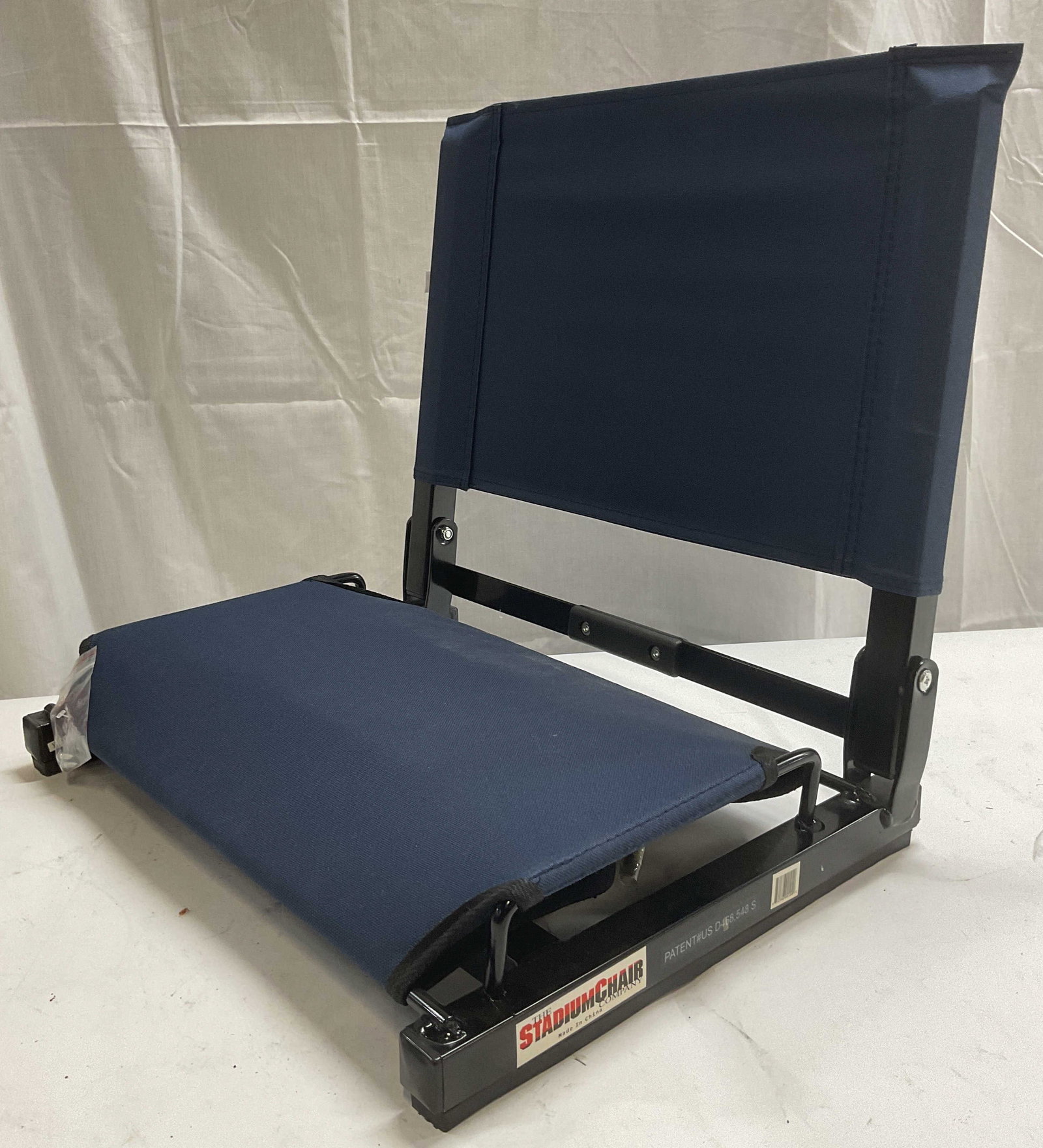 Stadium Chair Company Blue Stadium Chair: The Stadium Chair Company blue stadium chair. Chair attaches to stadium seat. Folds for travel. Steel frame and canvas seat. Reads Greeley Sports Boosters to reverse. Trademarked on frame. Like New, s