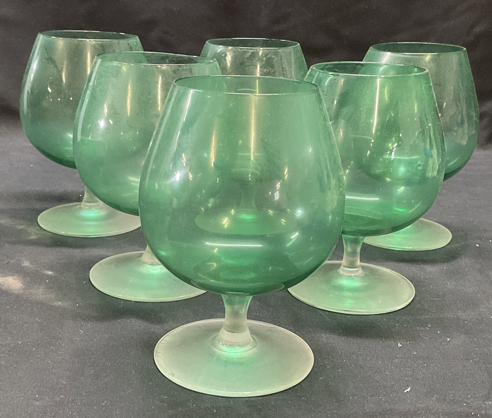 Set 6 Green & Clear Wine Glasses: Set of 6 green and clear toned wine glasses. Measure approx. 3 x 5 inches each. All pieces have some surface wear including scratching observed. Wine glass, green wine glass, glassware, stemware, Barw