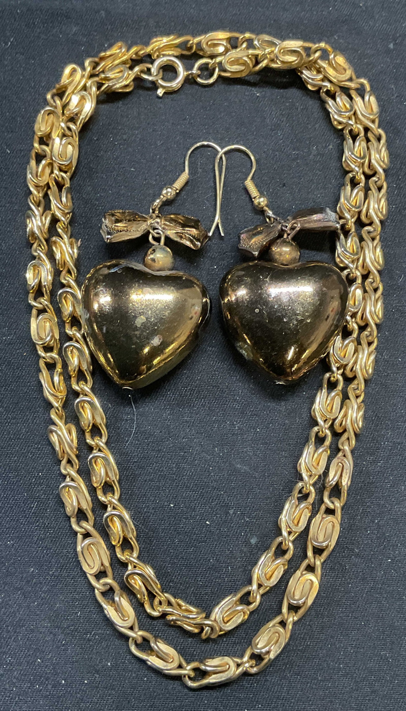 Lot 2 Vintage Gold Tone Chain & Heart Earrings: Lot of 2 vintage jewelry pieces. Gold tone chain necklace. Drop length approx. 11.5 inches. Gold tone heart and bow motif dangle earrings. Measure approx. 1.5 inches. Some surface wear to all pieces i