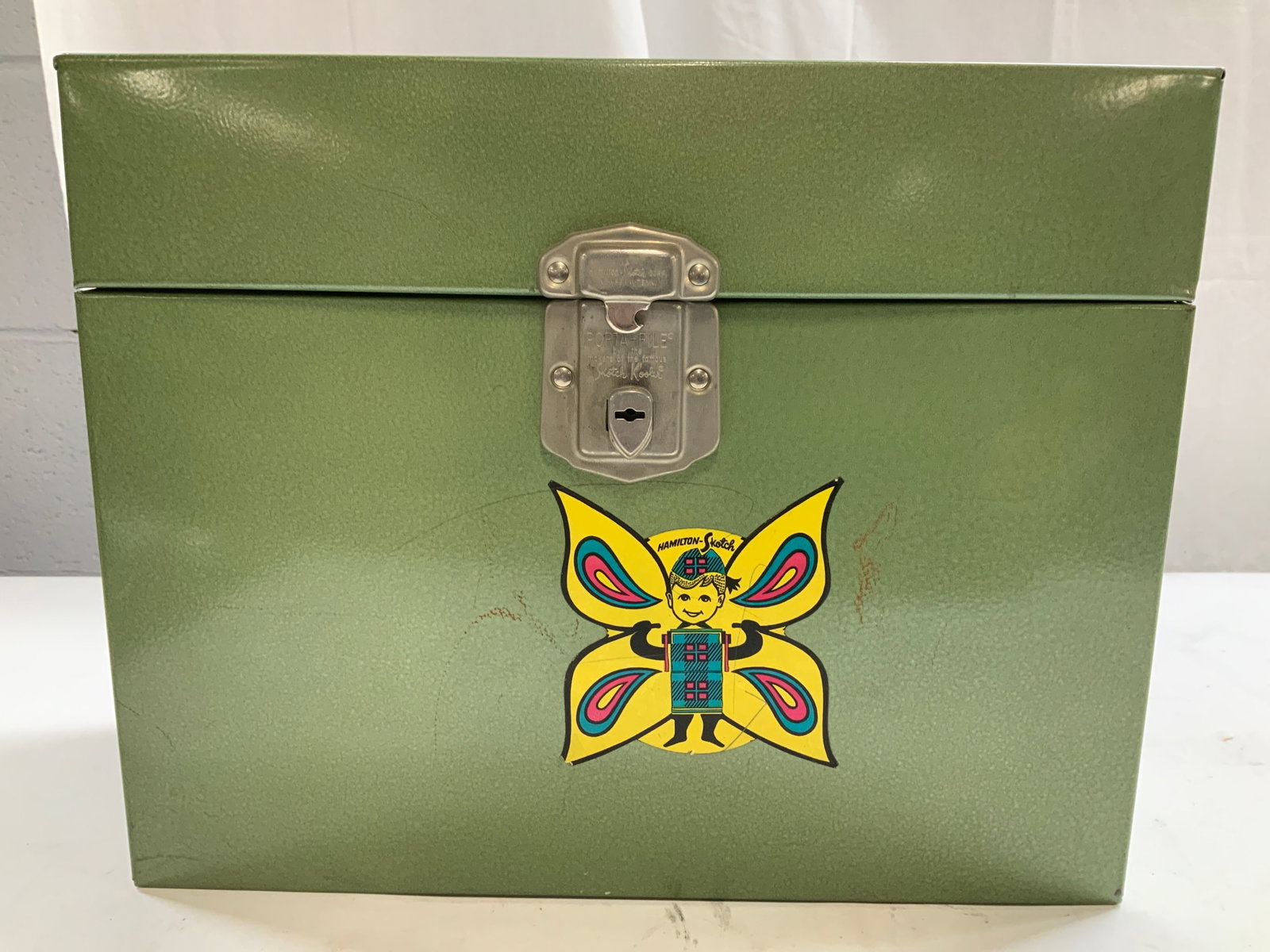 HAMILTON SKOTCH CORP Porta File Filing Case: Locking mechanism is inscribed HAMILTON SKOTCH CORP PORTA FILE. Piece is green toned and metal. Case has lid with metal handle. Includes hinged lid. Porta File Filing case measures approximately 12 in
