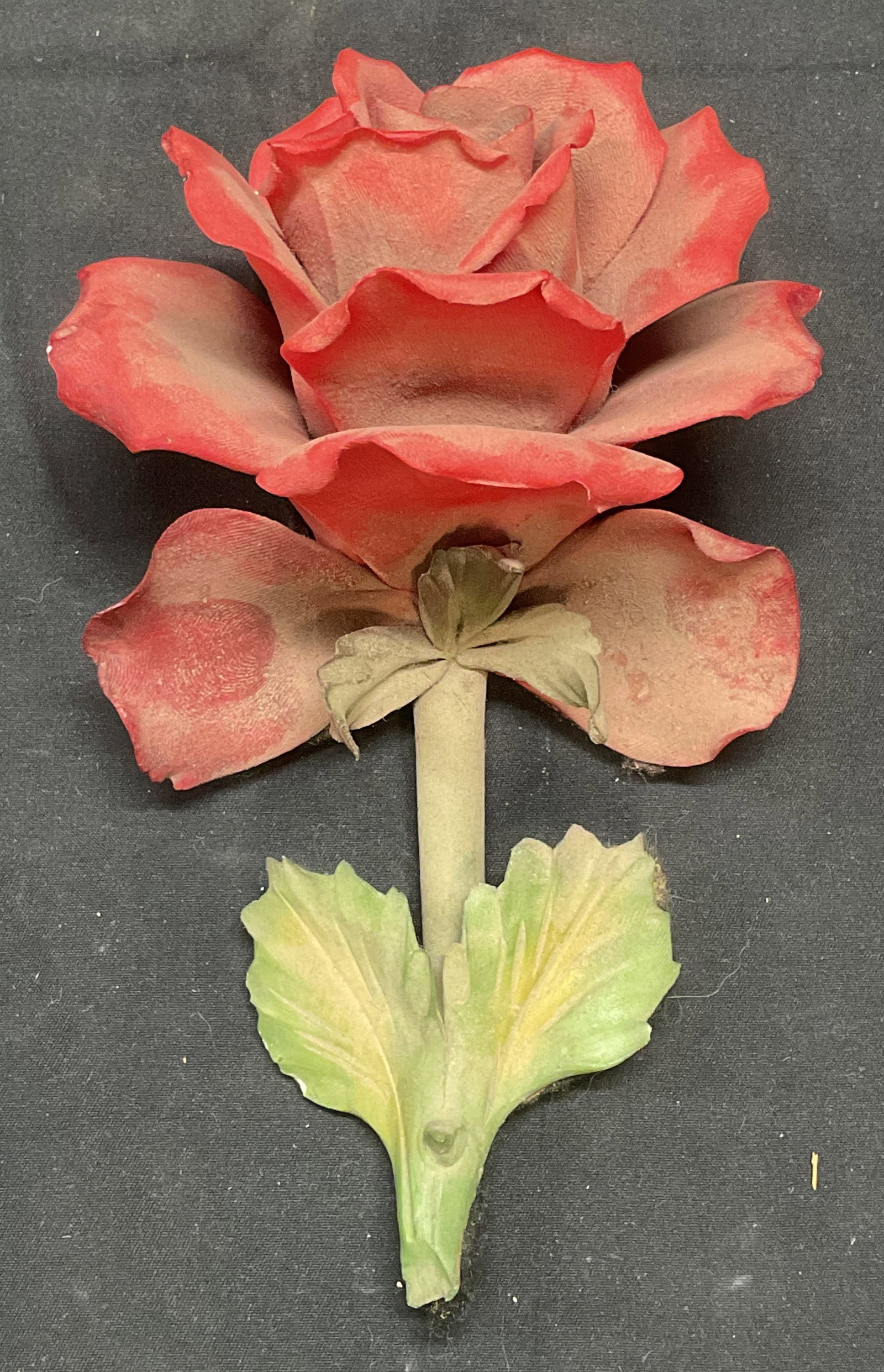 Porcelain Red Rose Figural: Porcelain rose flower figural in red and green. Measures approx. 7 x 4 inches. Some surface wear including small chips and residue observed. Flower, rose, red rose, rose figural, porcelain rose, flowe