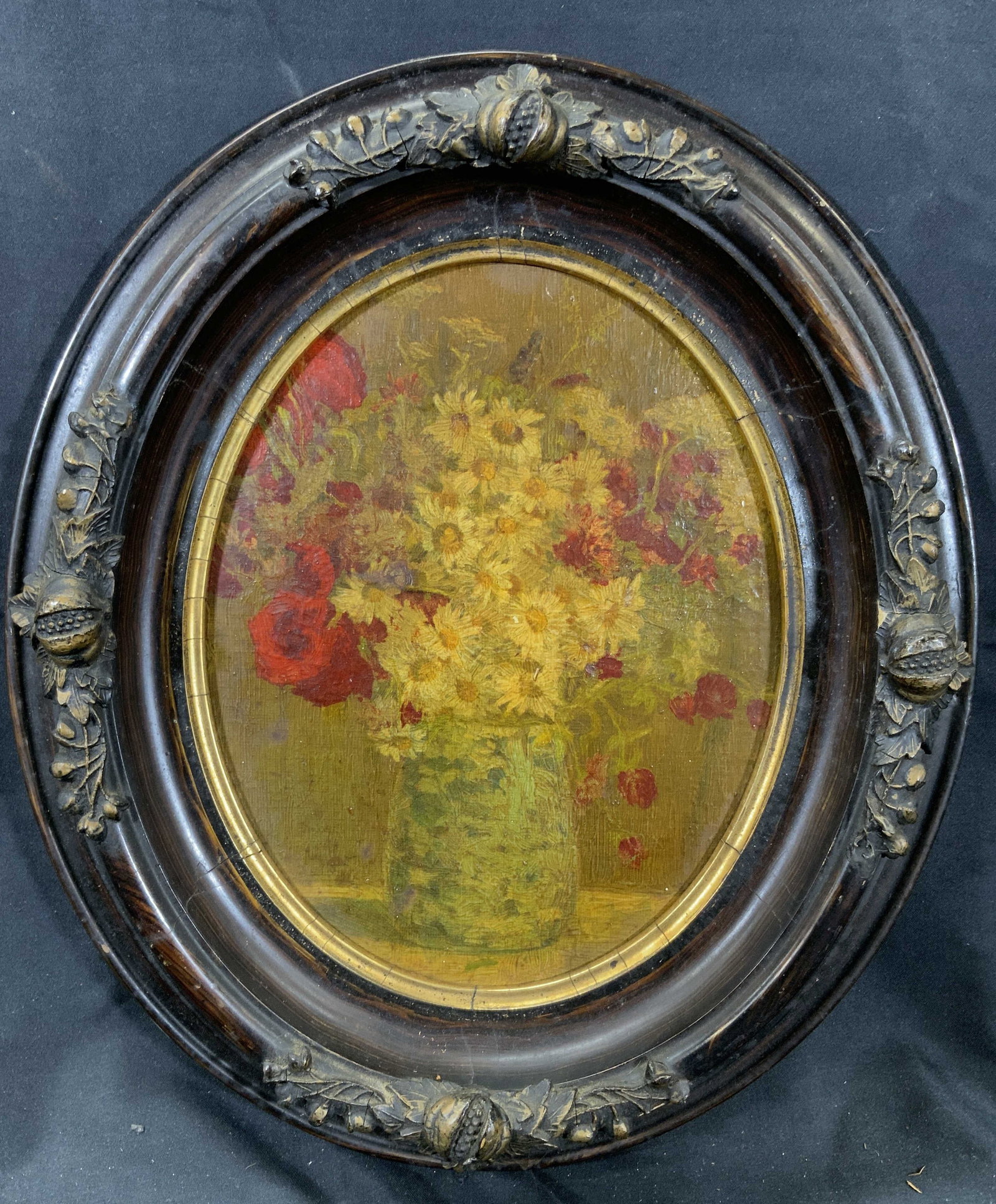 Antique Framed Oval Flower Vase Chromolithograph: Chromolithograph on board. Antique Printed. Subject depicts a still life of flowers in a vase. Framed in an oval wooden frame with foliage and fruit molding and gilt accent in inner window. Frame meas