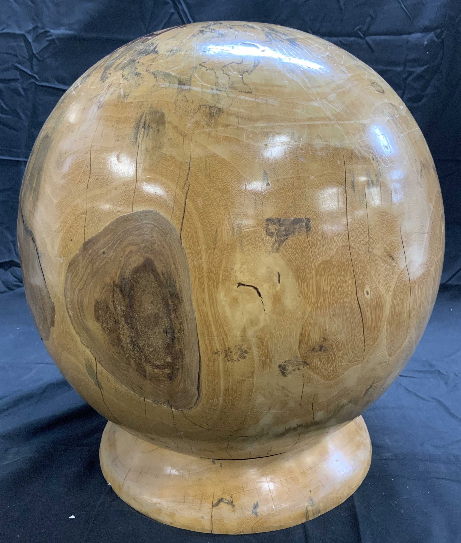 Wooden Spherical Sculpture W Base 15 In Diameter: Sculpture is tan toned and Wooden. Piece has spherical form. Base has circular form. Piece is significantly weighted. Sculpture measures approximately 16.5 inches tall 15 inches wide. Sculpture, woode