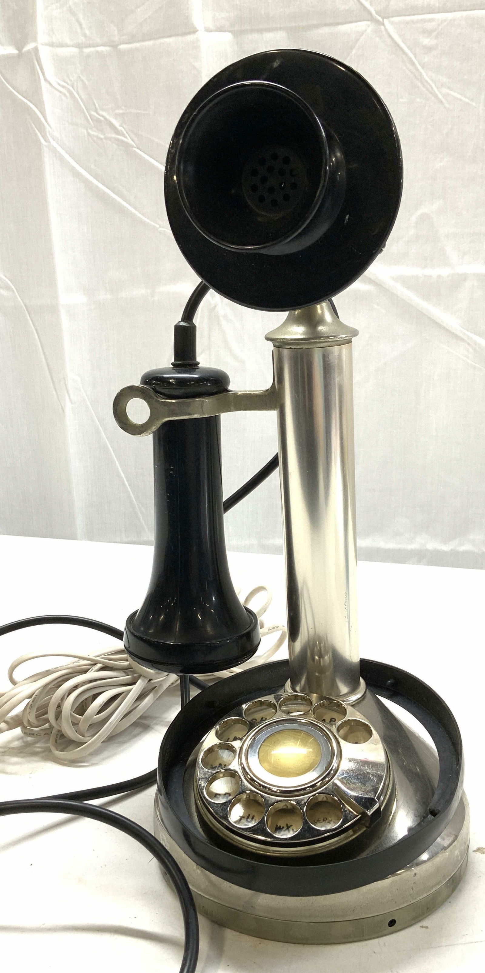Rotary Candlestick Metal Telephone: Vintage rotary telephone in the form of an antique version of a candlestick telephone. Comes with telephone wire. Not tested for working condition. Underside rubber base needs to be re- set. In silver